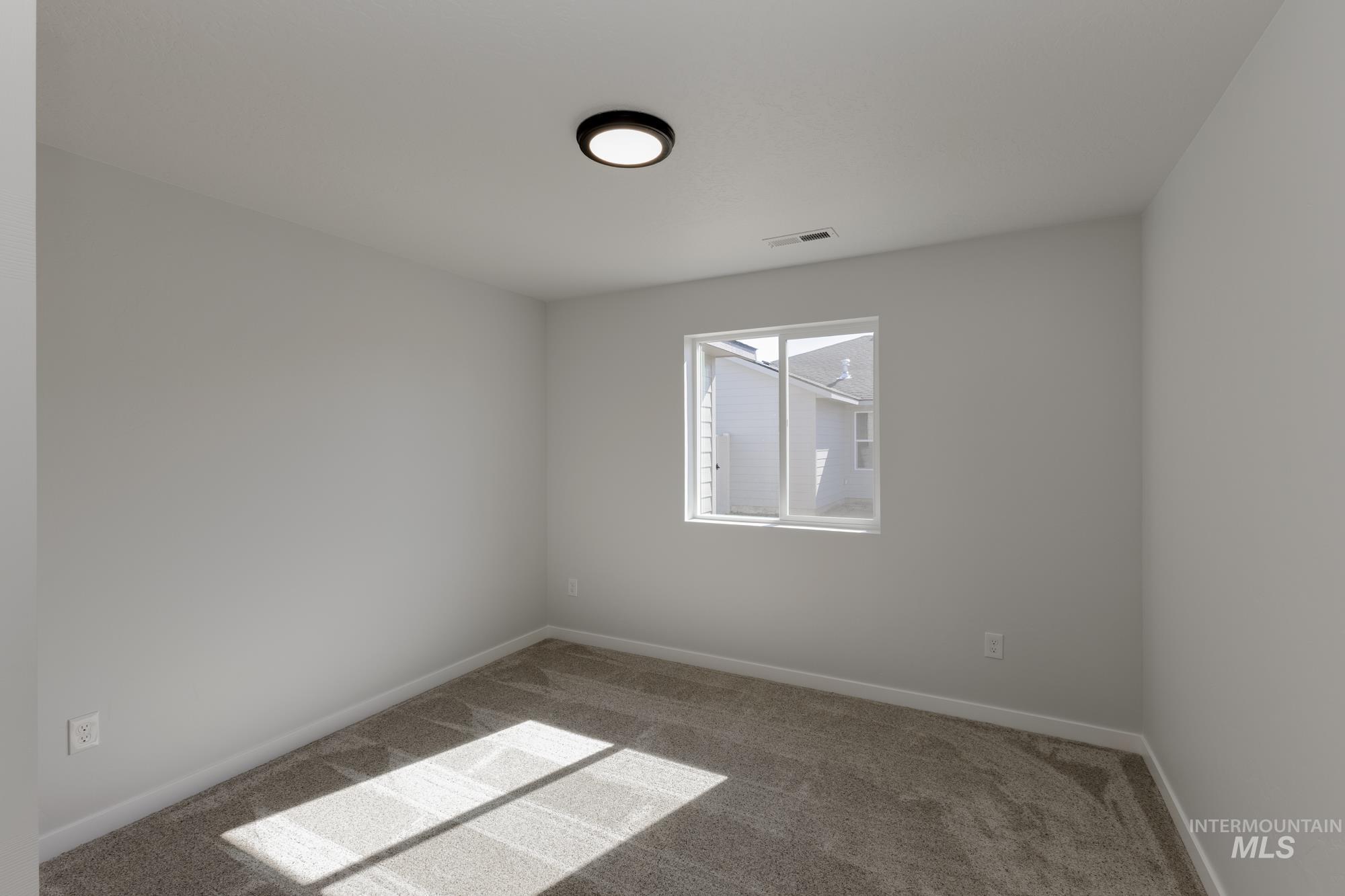 Carpeted empty room with baseboards