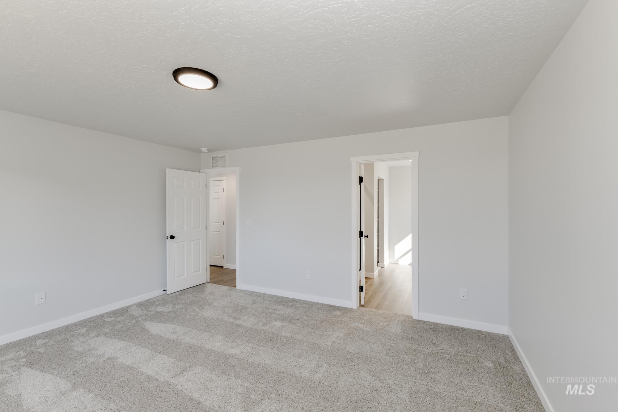 Unfurnished bedroom with carpet and a textured ceiling