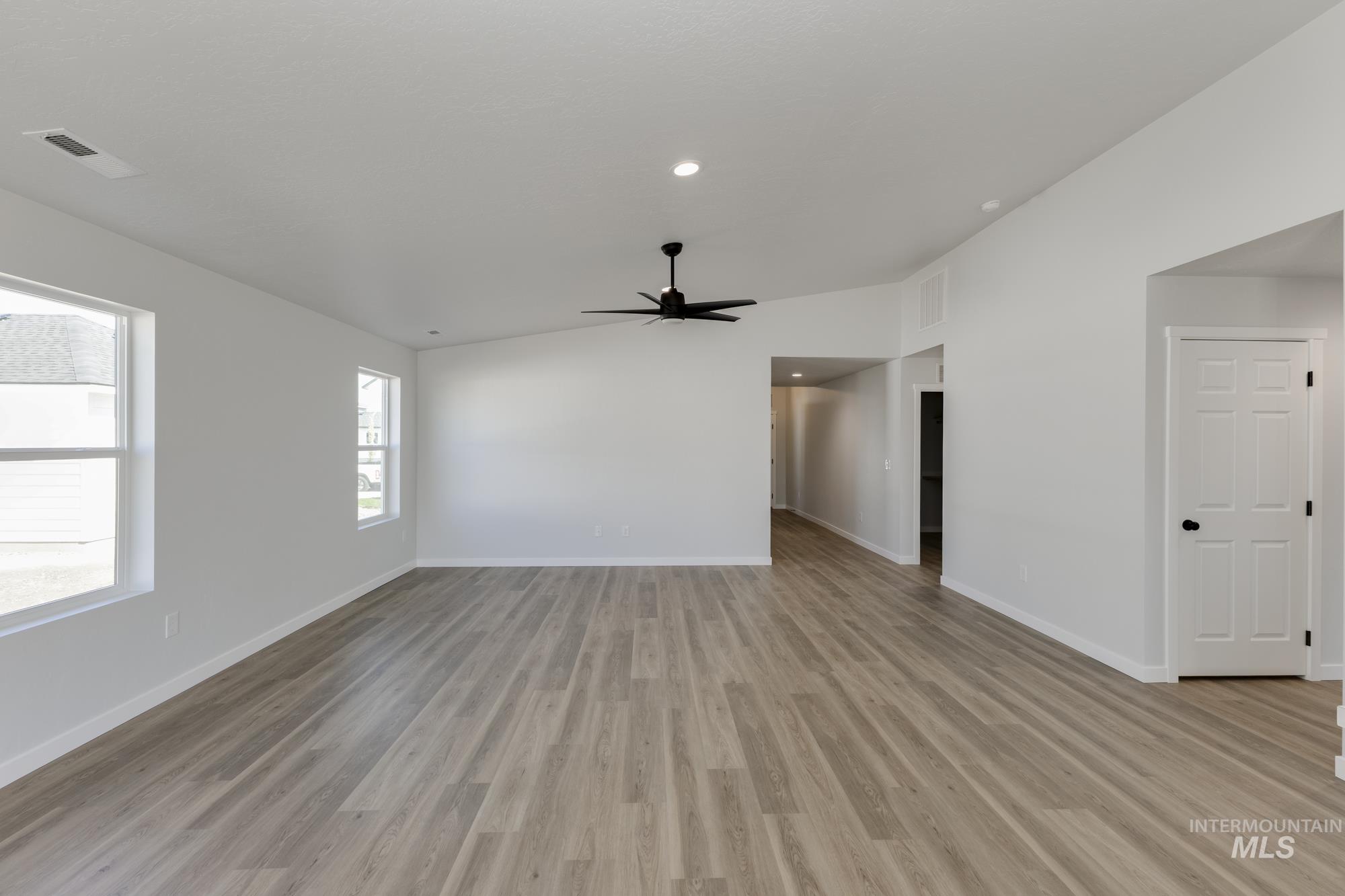 Unfurnished room with vaulted ceiling, light wood-style floors, a ceiling fan, and recessed lighting