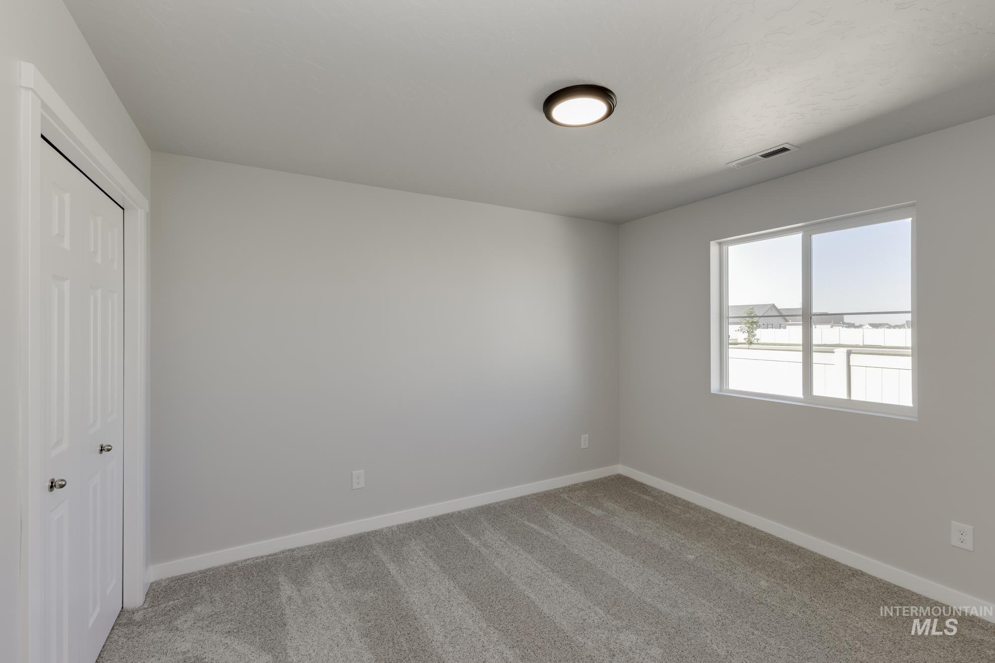 Unfurnished bedroom with light carpet and a closet