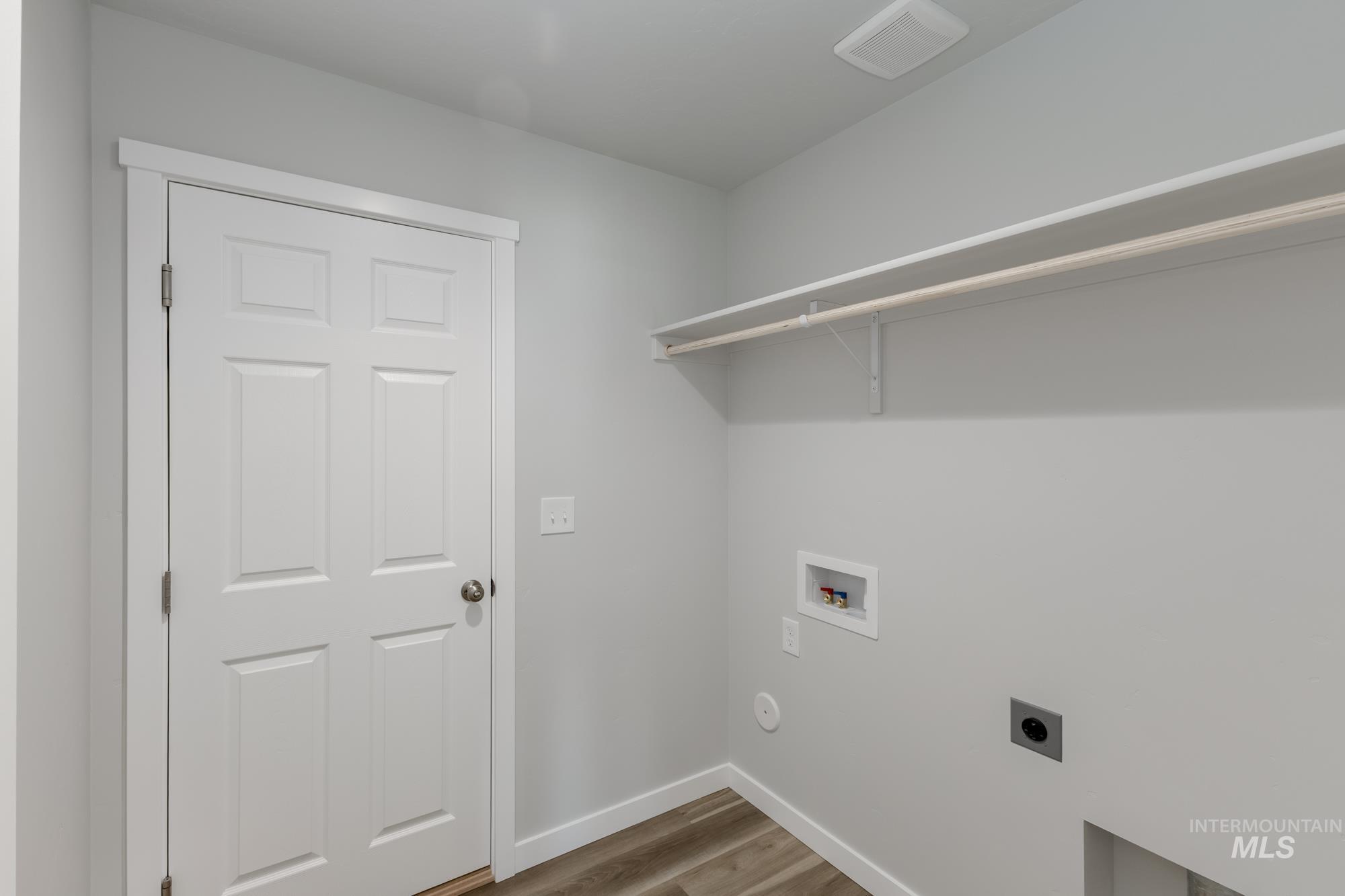 Laundry room featuring light wood-style floors, hookup for a washing machine, and hookup for an electric dryer