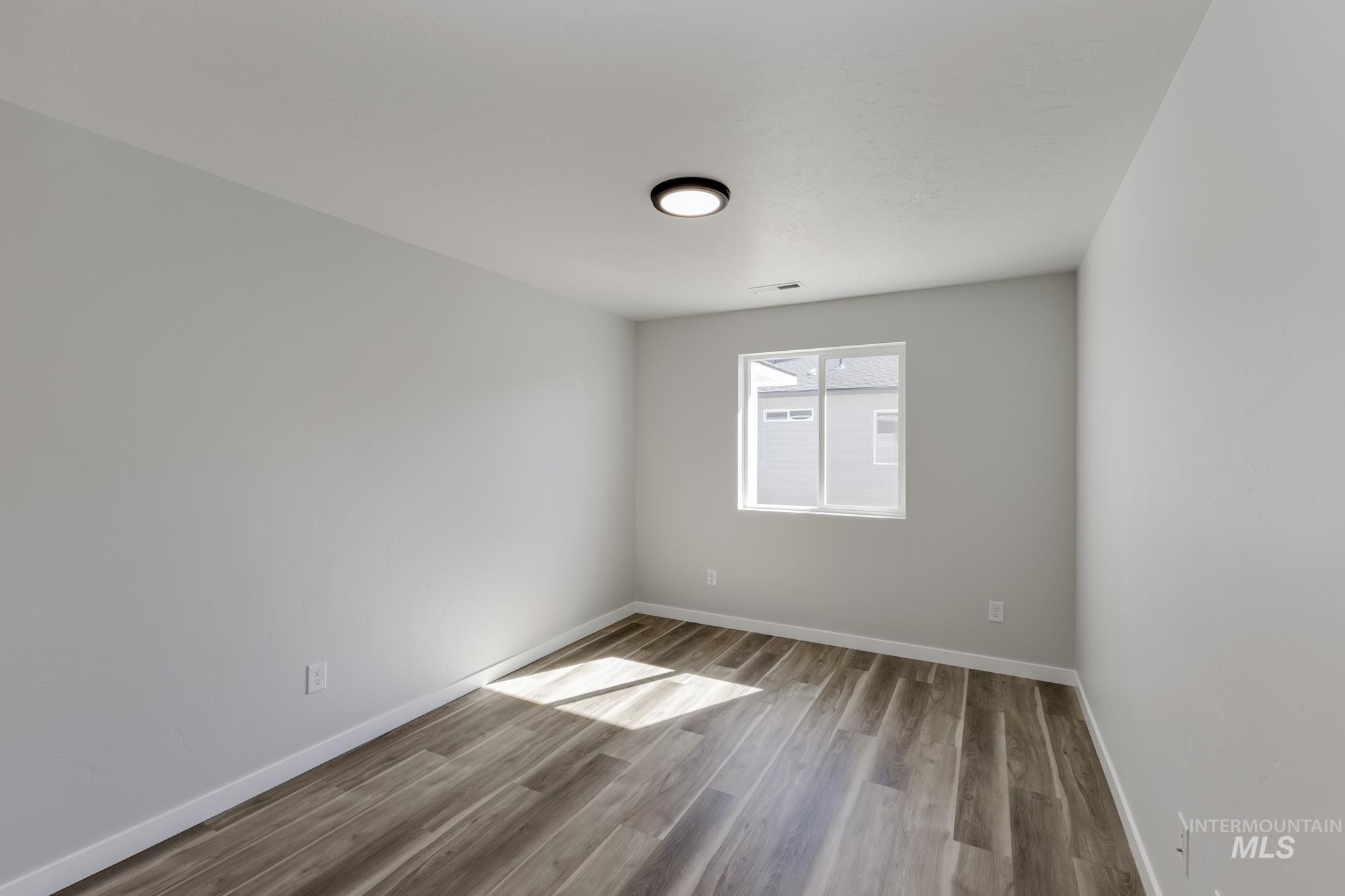 Unfurnished room featuring light wood-style flooring and baseboards