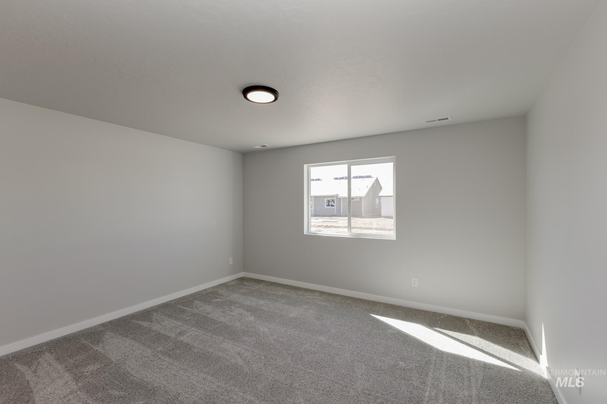 Spare room featuring carpet floors and baseboards