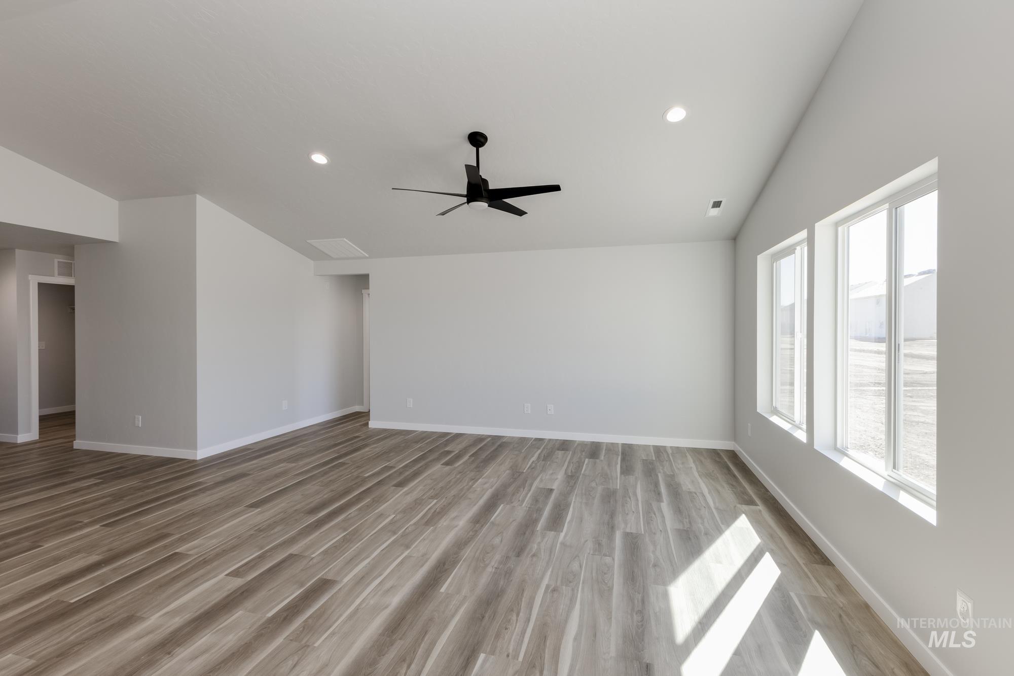 Unfurnished living room with light wood-style floors, vaulted ceiling, recessed lighting, and ceiling fan