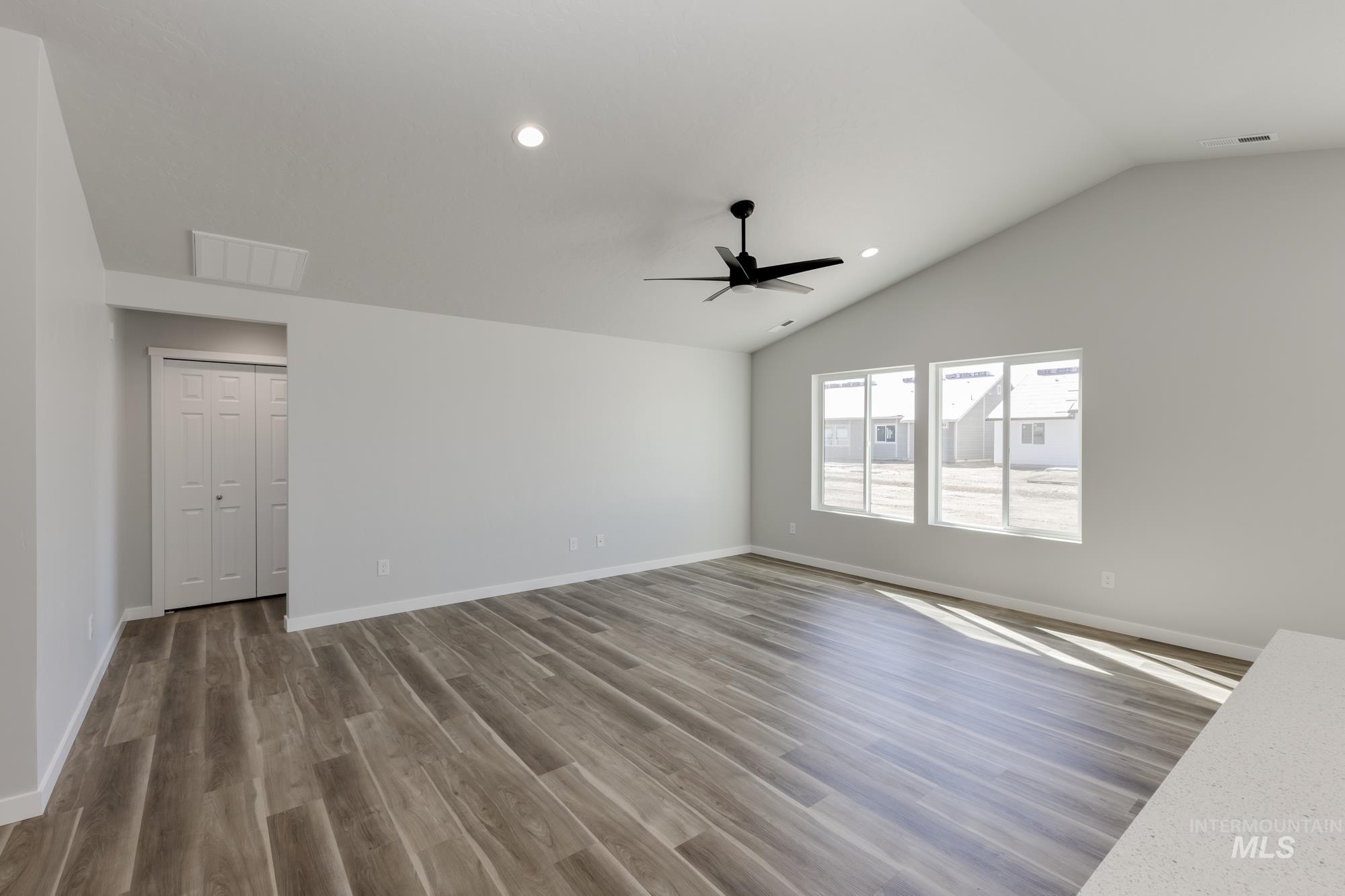 Unfurnished room with recessed lighting, wood finished floors, lofted ceiling, and ceiling fan
