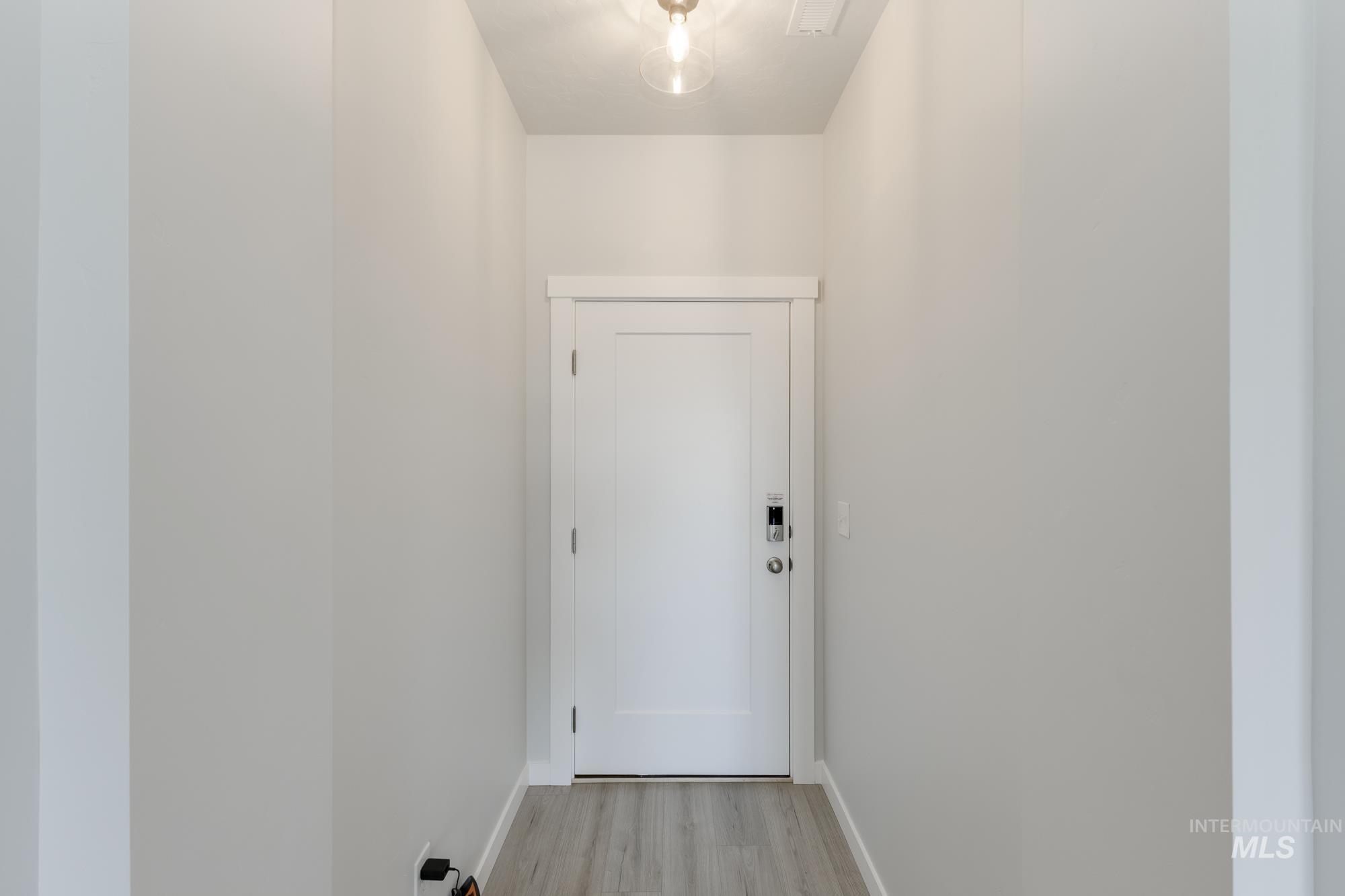 Doorway to outside featuring wood finished floors and baseboards