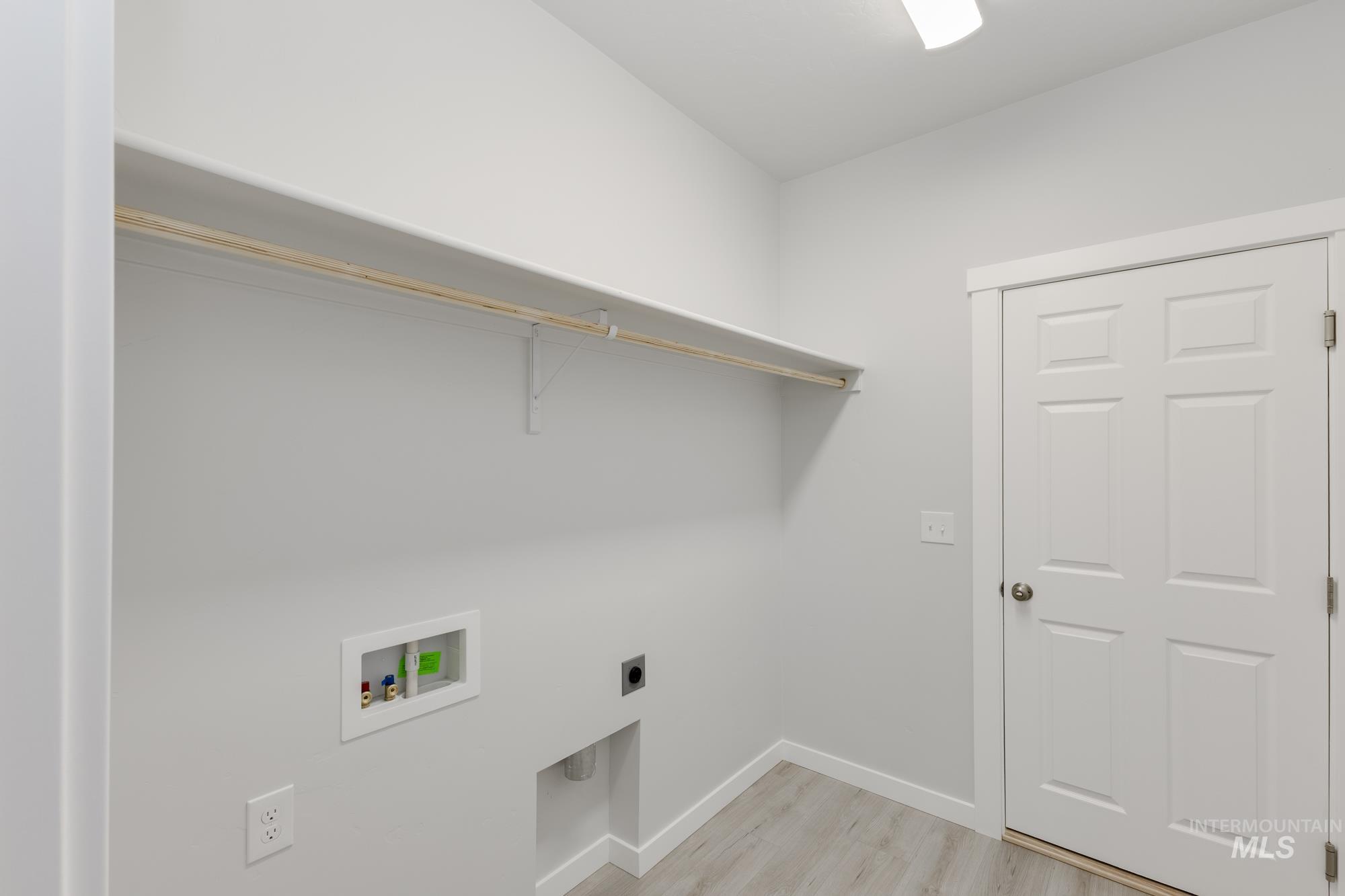 Laundry room with light wood-style flooring, electric dryer hookup, and washer hookup