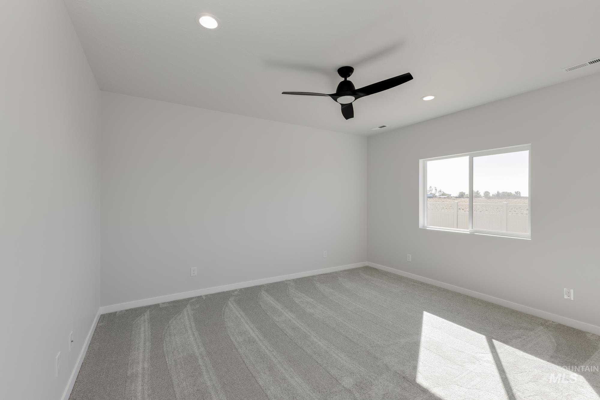 Empty room featuring light colored carpet, recessed lighting, and a ceiling fan