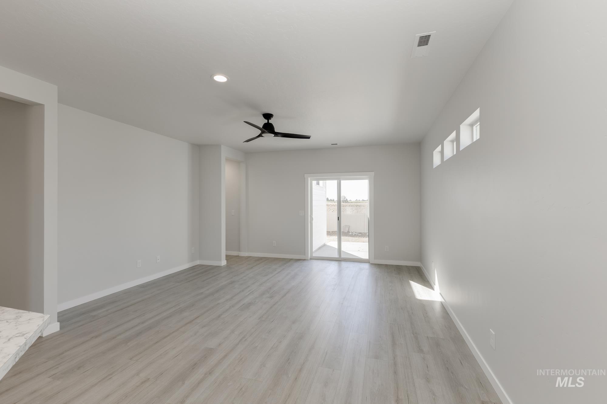 Spare room featuring light wood-style flooring, a ceiling fan, and recessed lighting