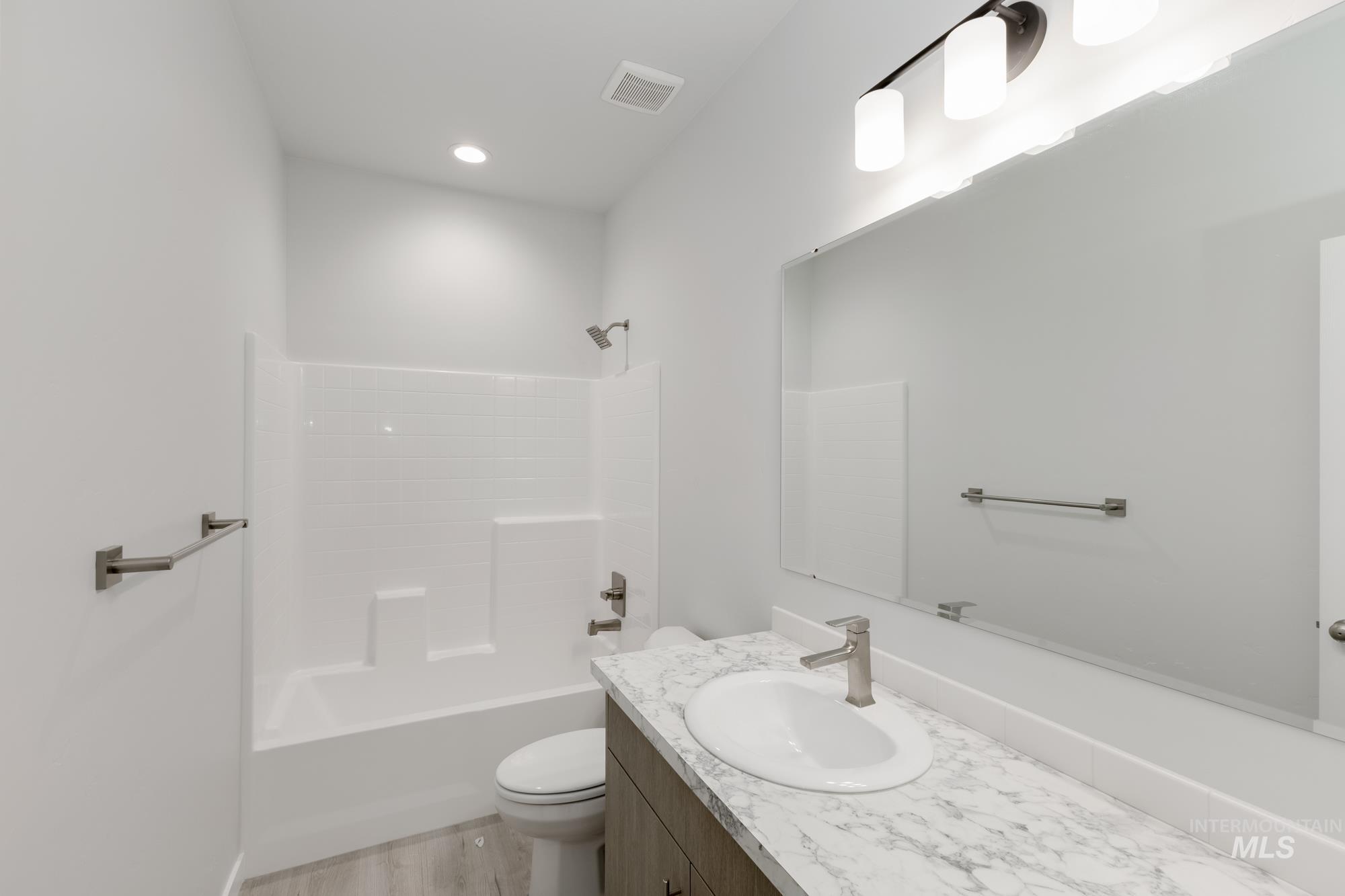 Full bath featuring vanity, bathing tub / shower combination, light wood-style flooring, and recessed lighting