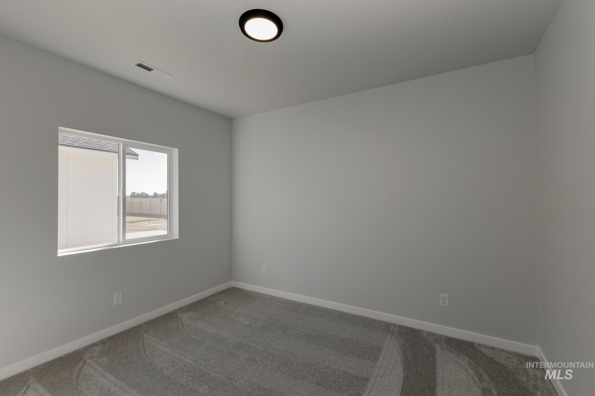 Carpeted empty room featuring baseboards