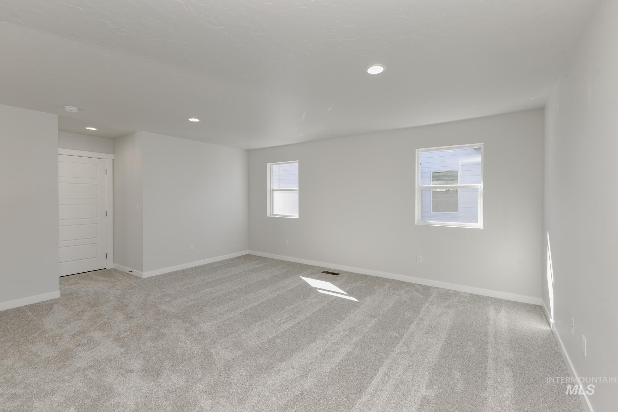 Spare room featuring light carpet and recessed lighting