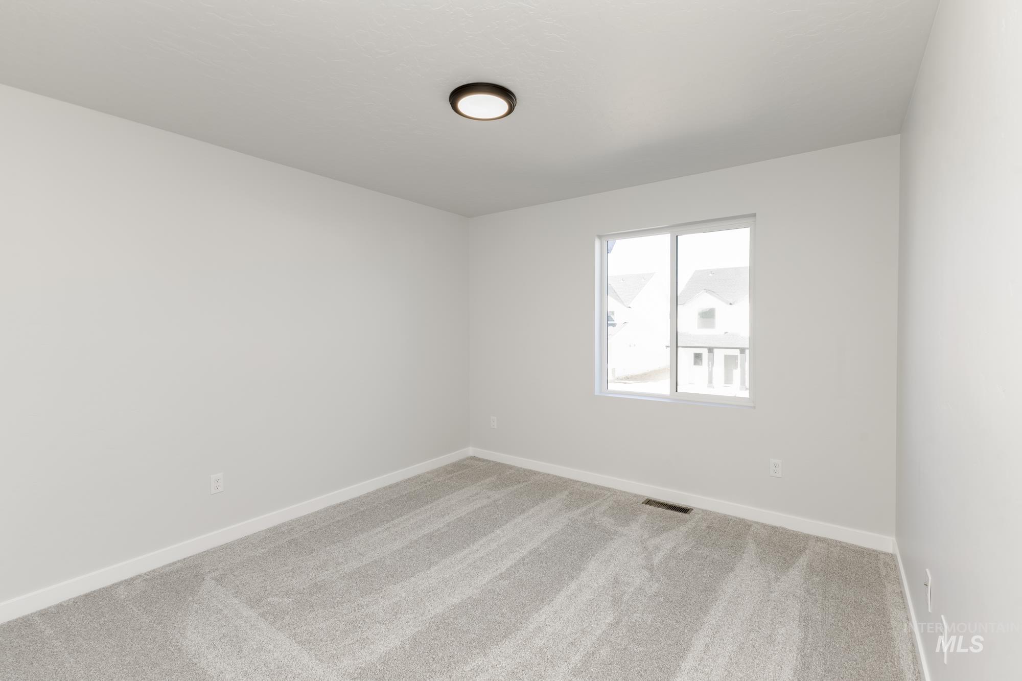 Carpeted empty room featuring baseboards