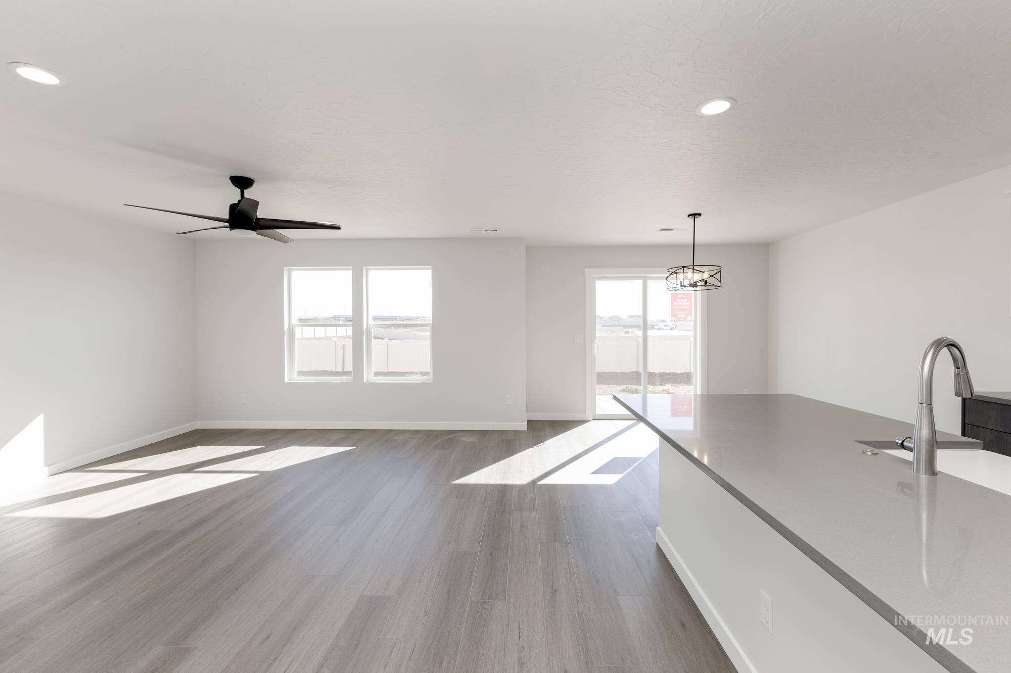 Unfurnished living room with dark wood-type flooring, recessed lighting, and a ceiling fan
