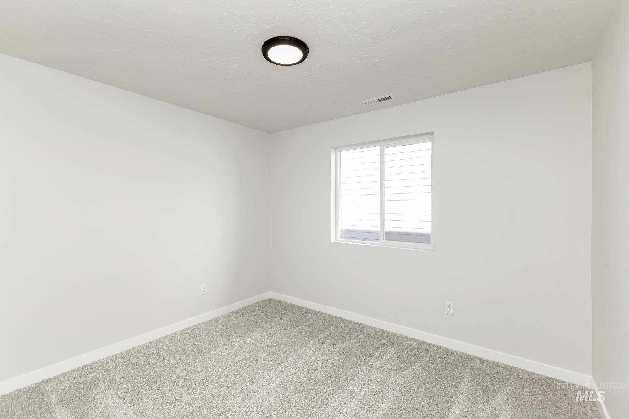 Empty room featuring carpet floors and a textured ceiling