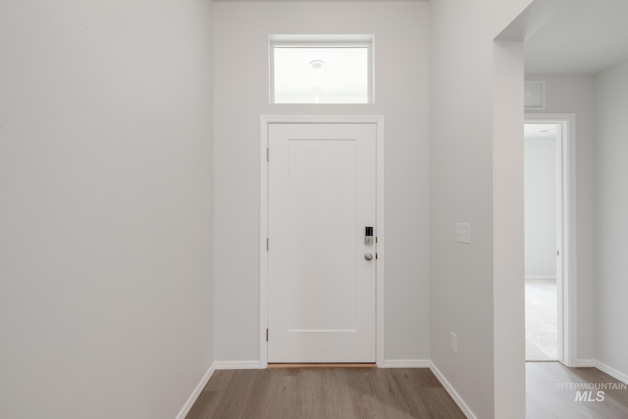 Foyer entrance featuring light wood-style floors and baseboards