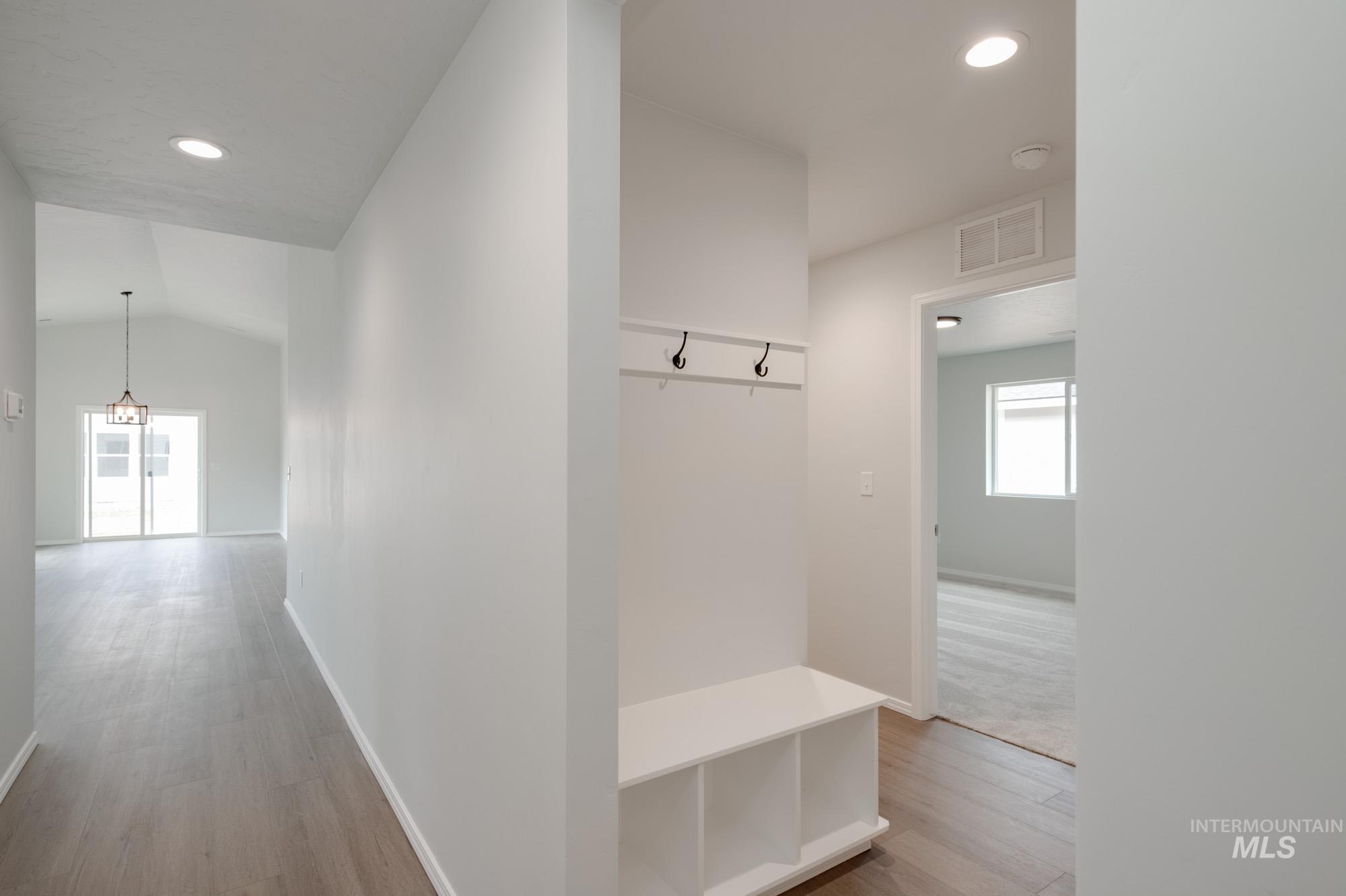 Mudroom with light wood-style floors, recessed lighting, and vaulted ceiling