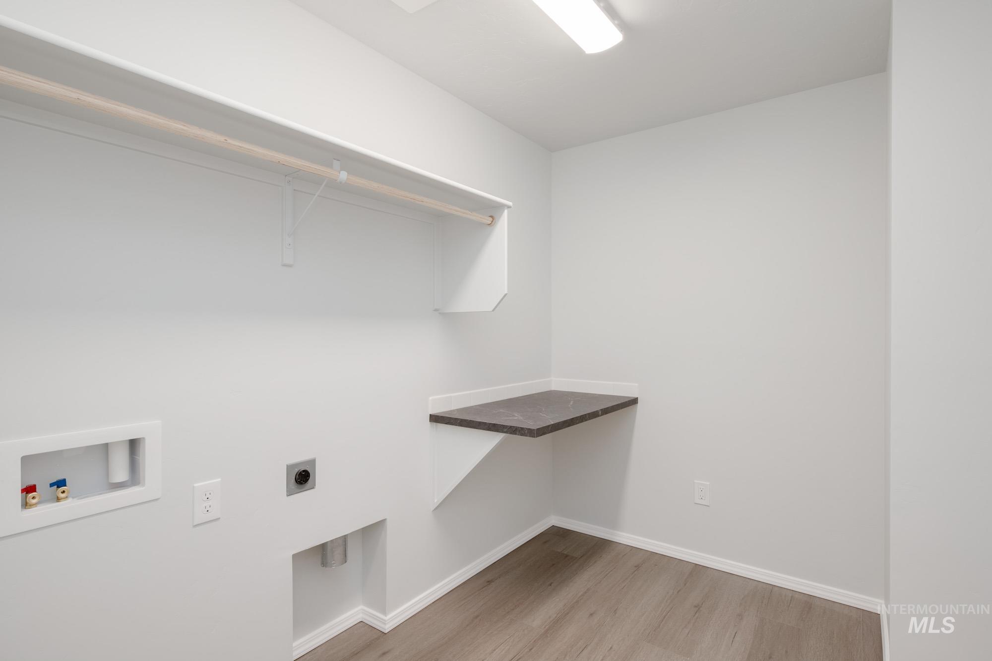 Laundry area featuring light wood-type flooring, washer hookup, and hookup for an electric dryer