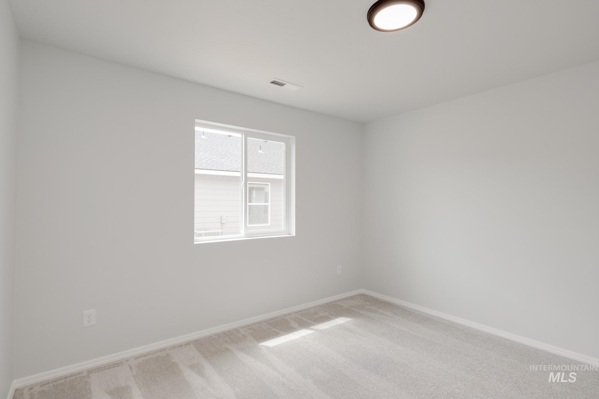 Carpeted empty room with baseboards