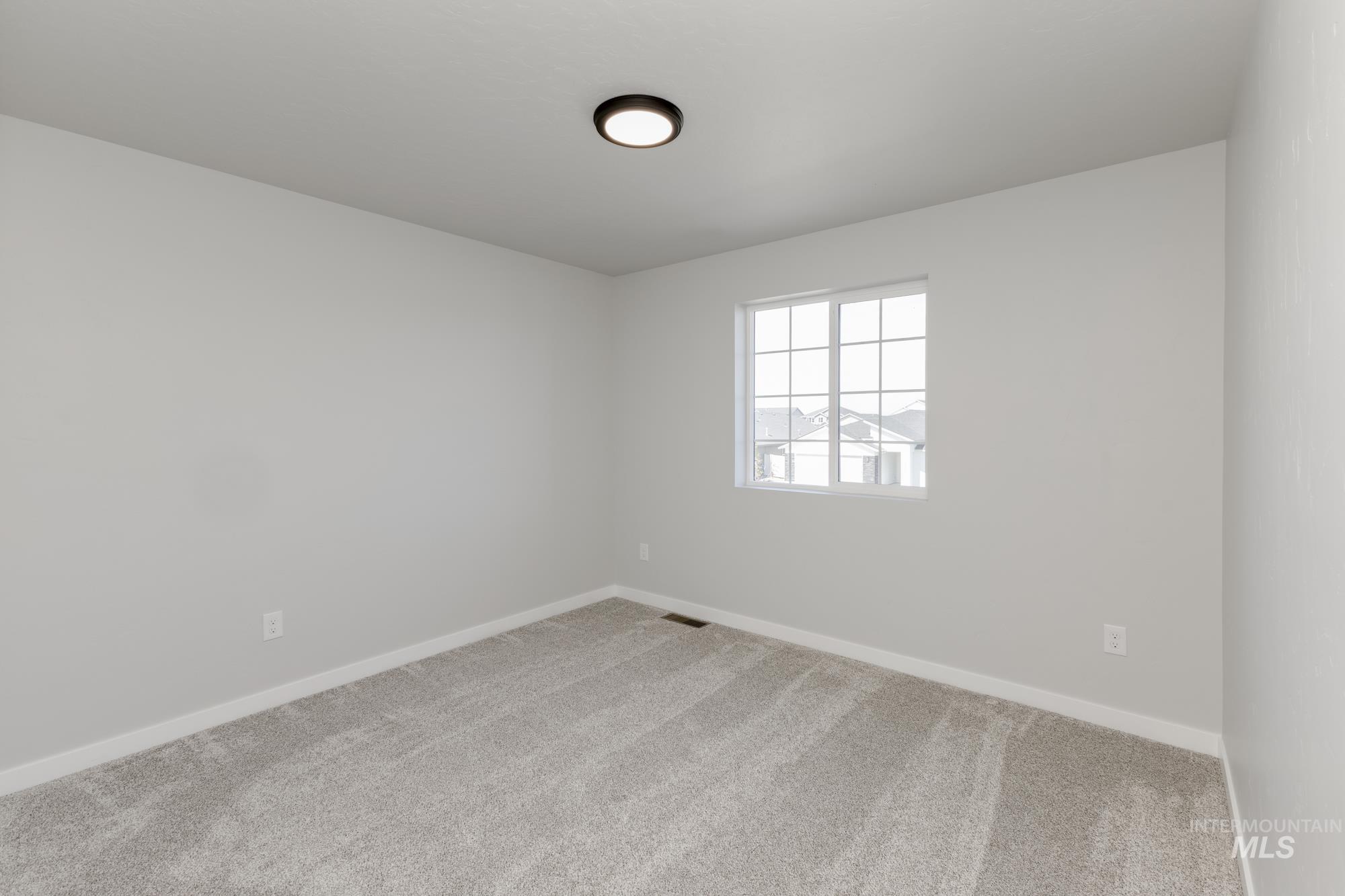Carpeted empty room featuring baseboards
