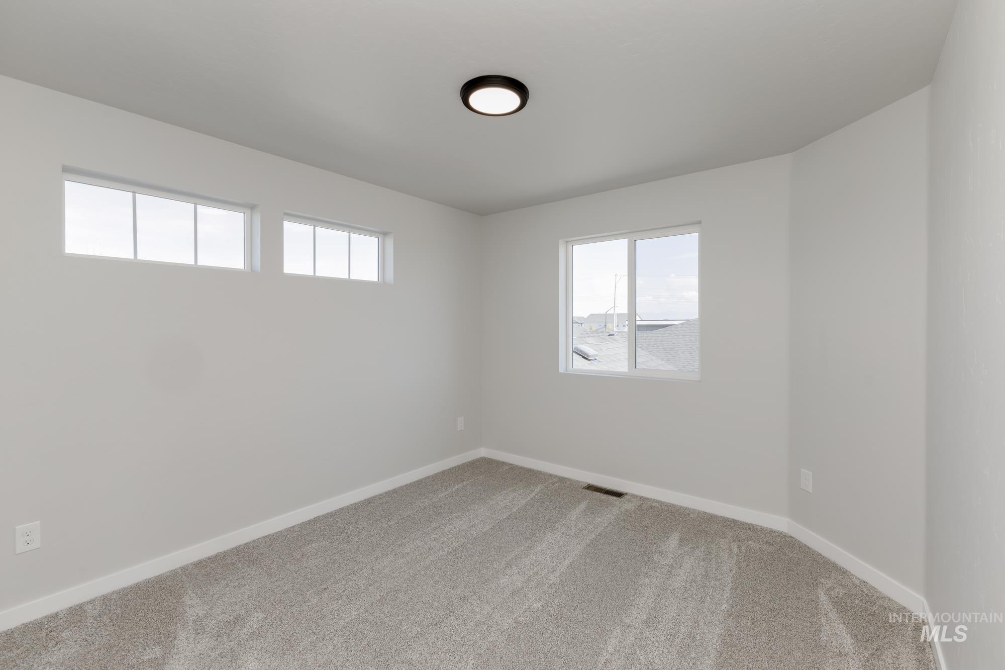 Spare room with light colored carpet and baseboards