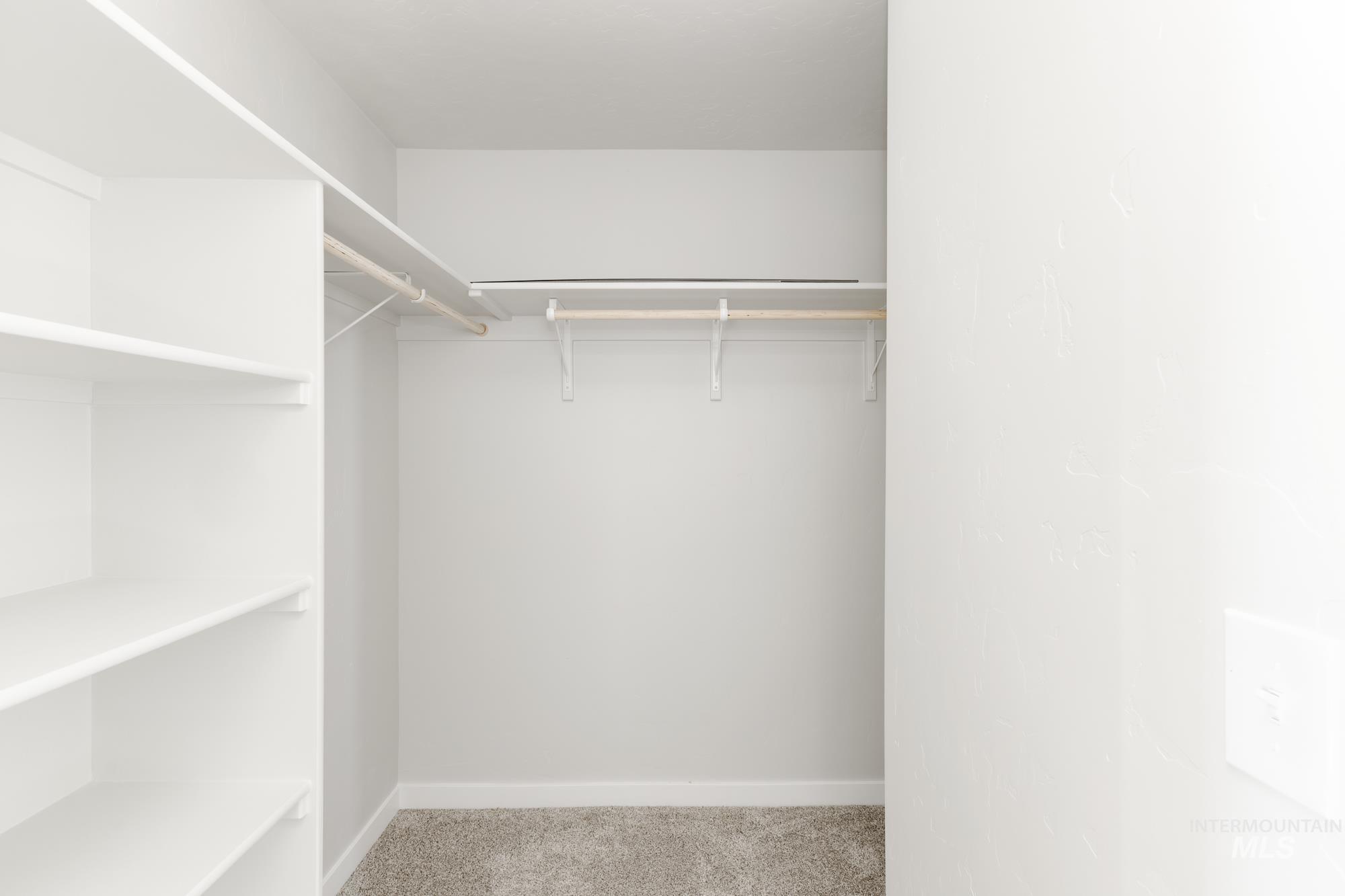 Spacious closet with light colored carpet