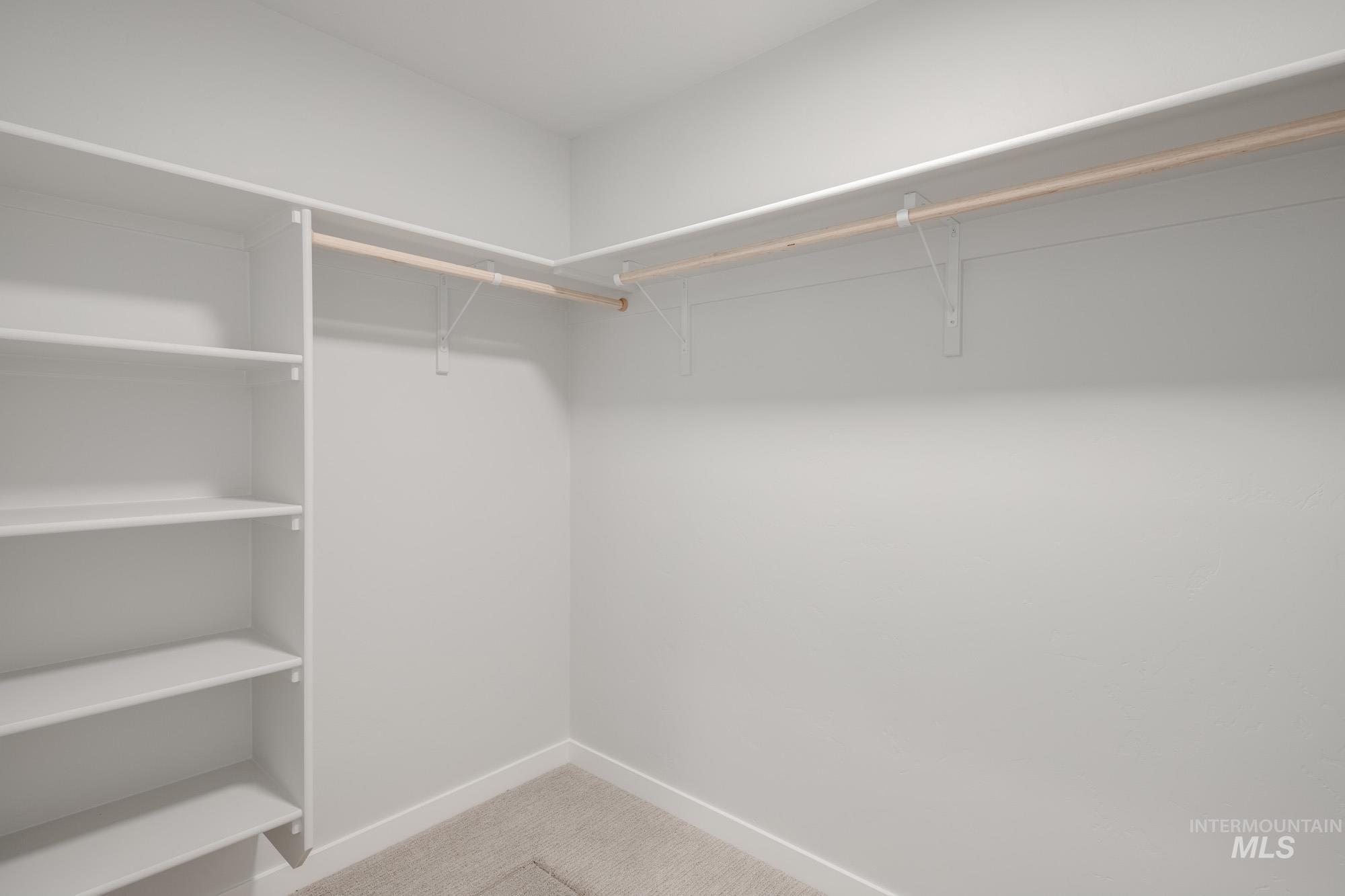 Spacious closet with light colored carpet