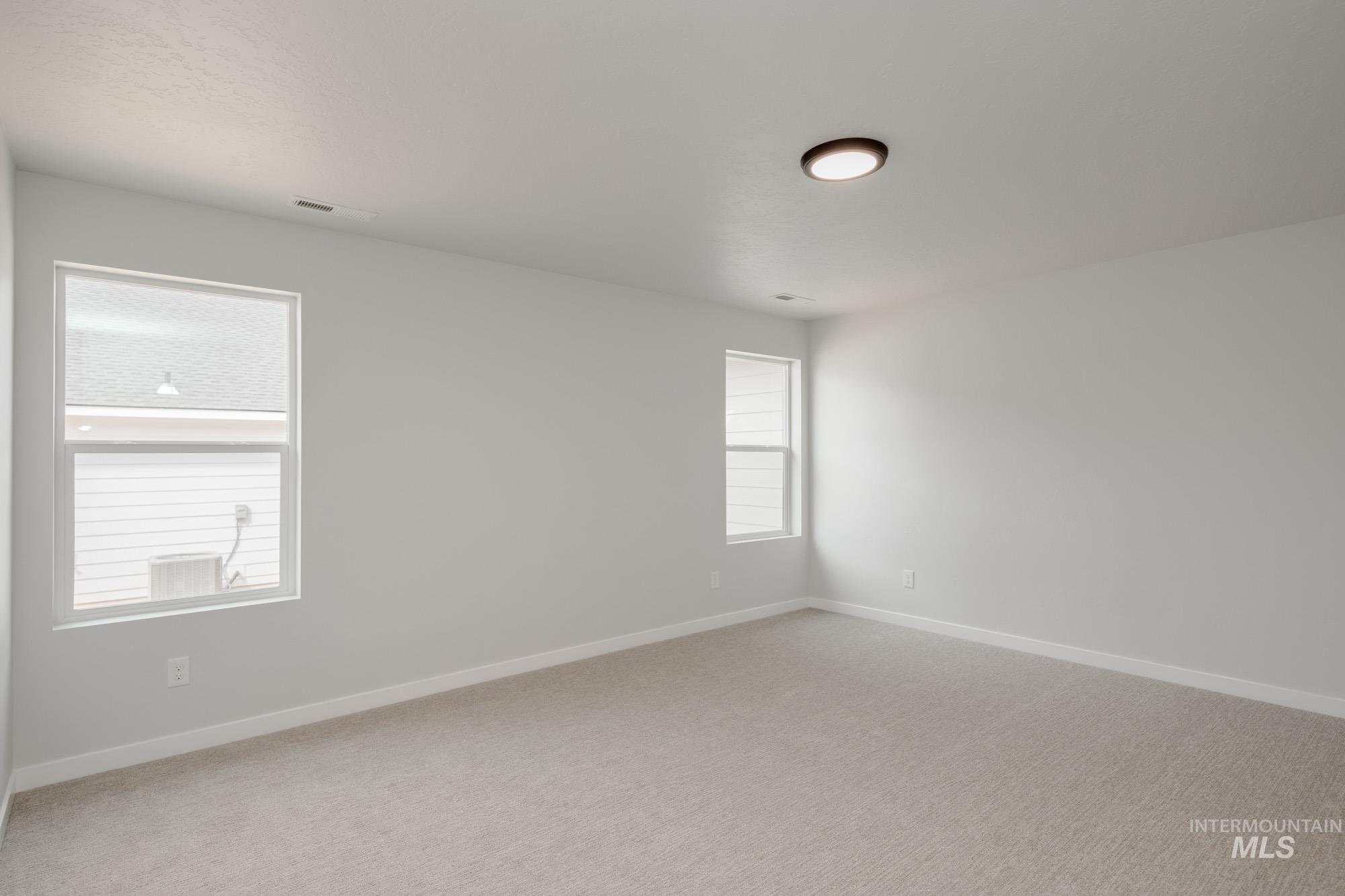 Empty room featuring baseboards and light colored carpet