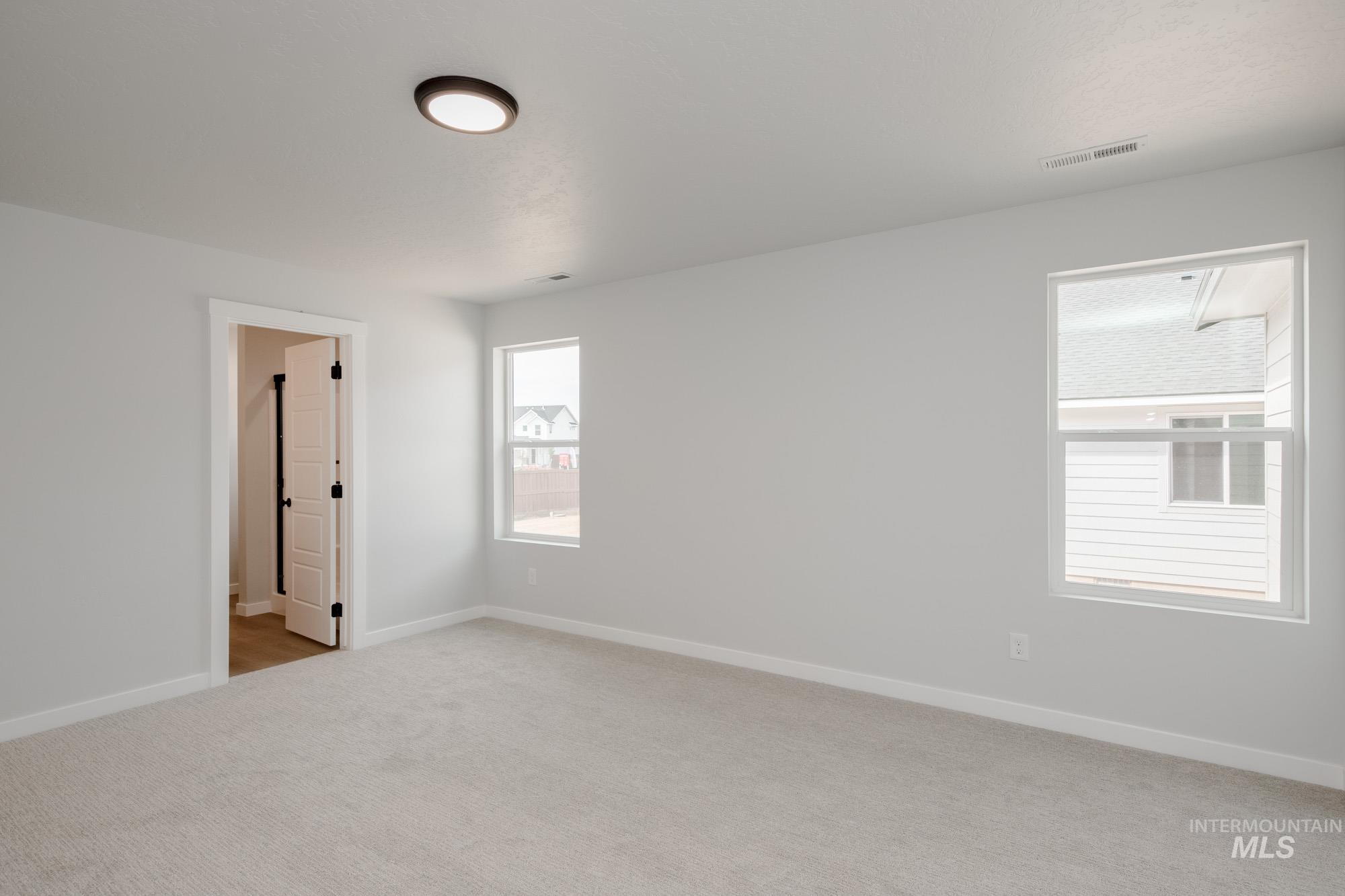 Unfurnished bedroom with baseboards and light colored carpet