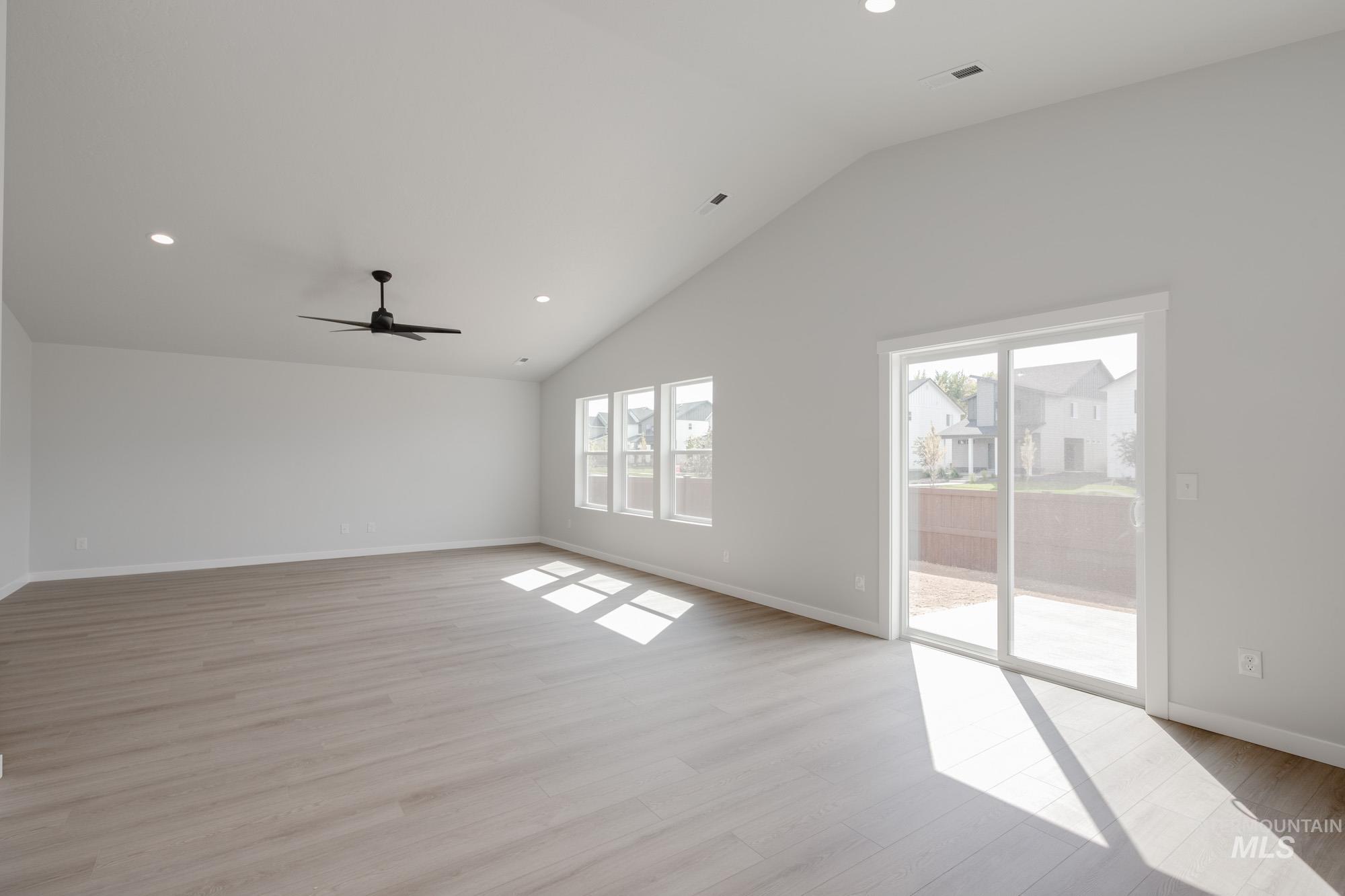 Unfurnished living room featuring recessed lighting, light wood-style flooring, ceiling fan, and high vaulted ceiling