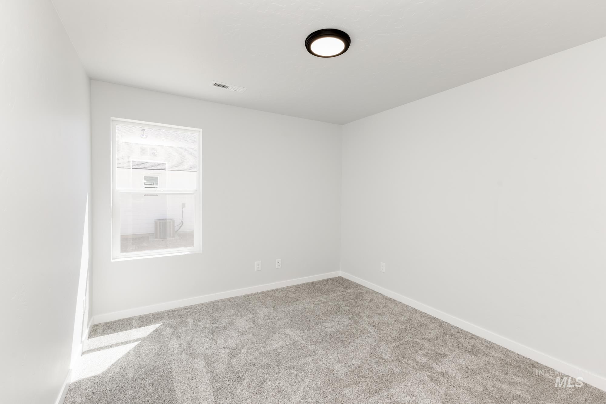 Carpeted spare room with baseboards