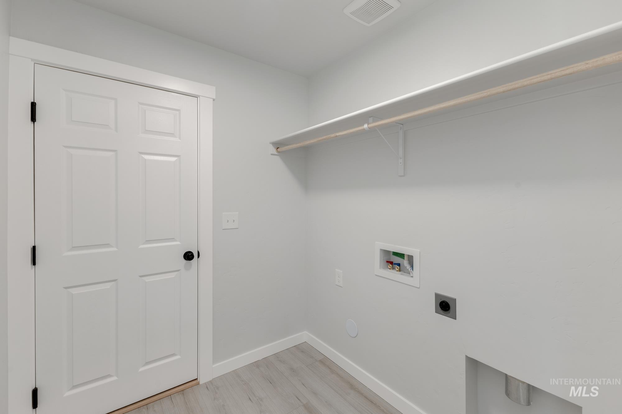 Washroom featuring washer hookup, hookup for an electric dryer, and light wood-type flooring
