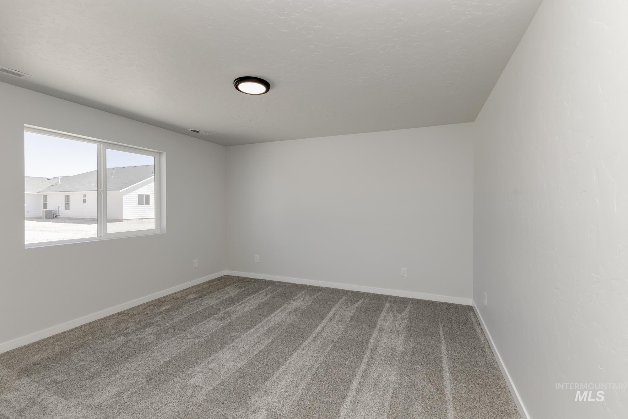 Empty room with light carpet and baseboards