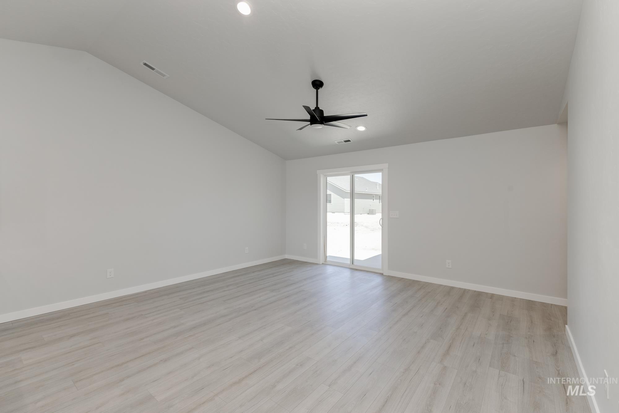 Spare room with lofted ceiling, light wood-type flooring, ceiling fan, and recessed lighting