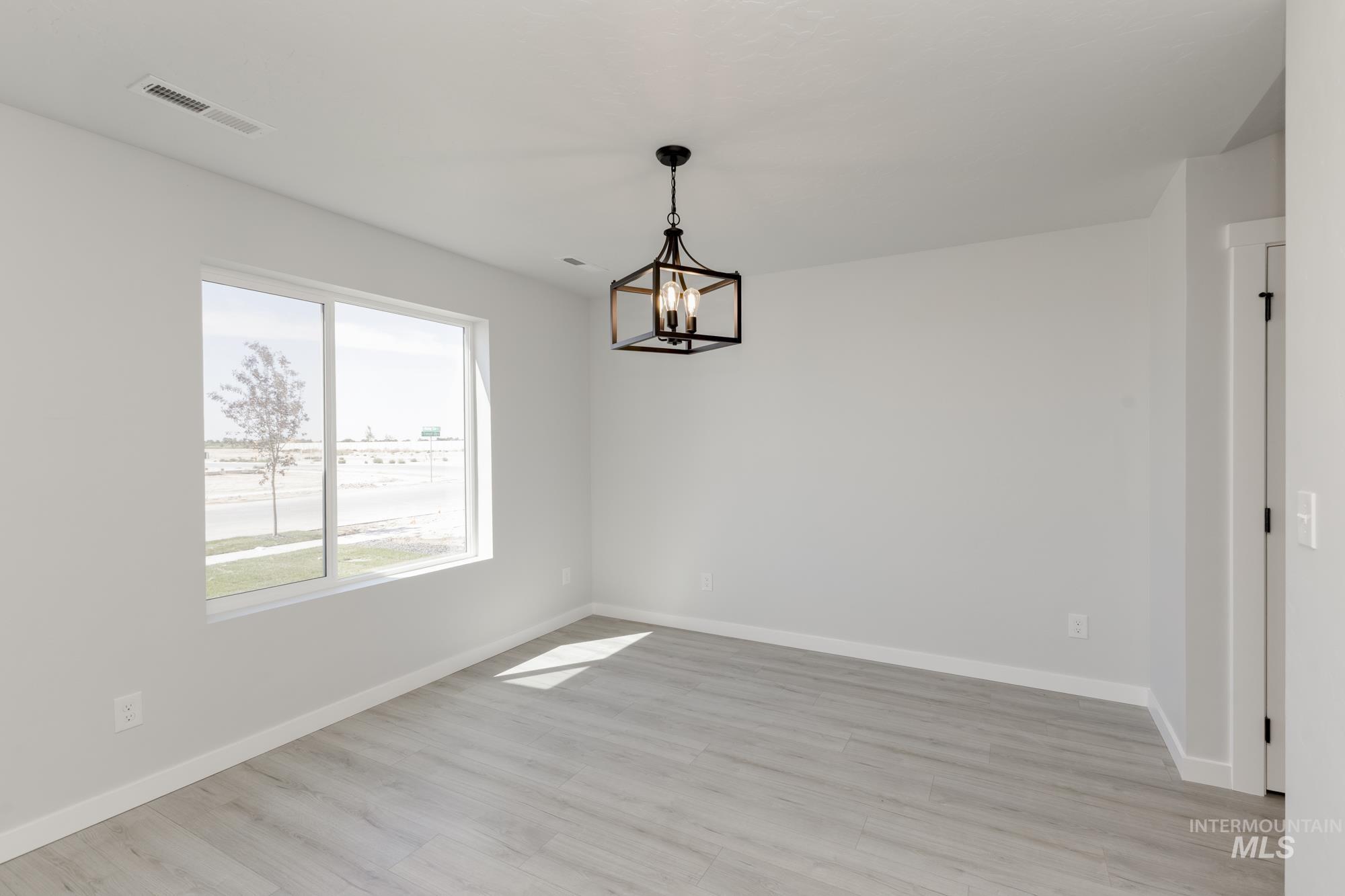 Unfurnished dining area with light wood finished floors and a chandelier