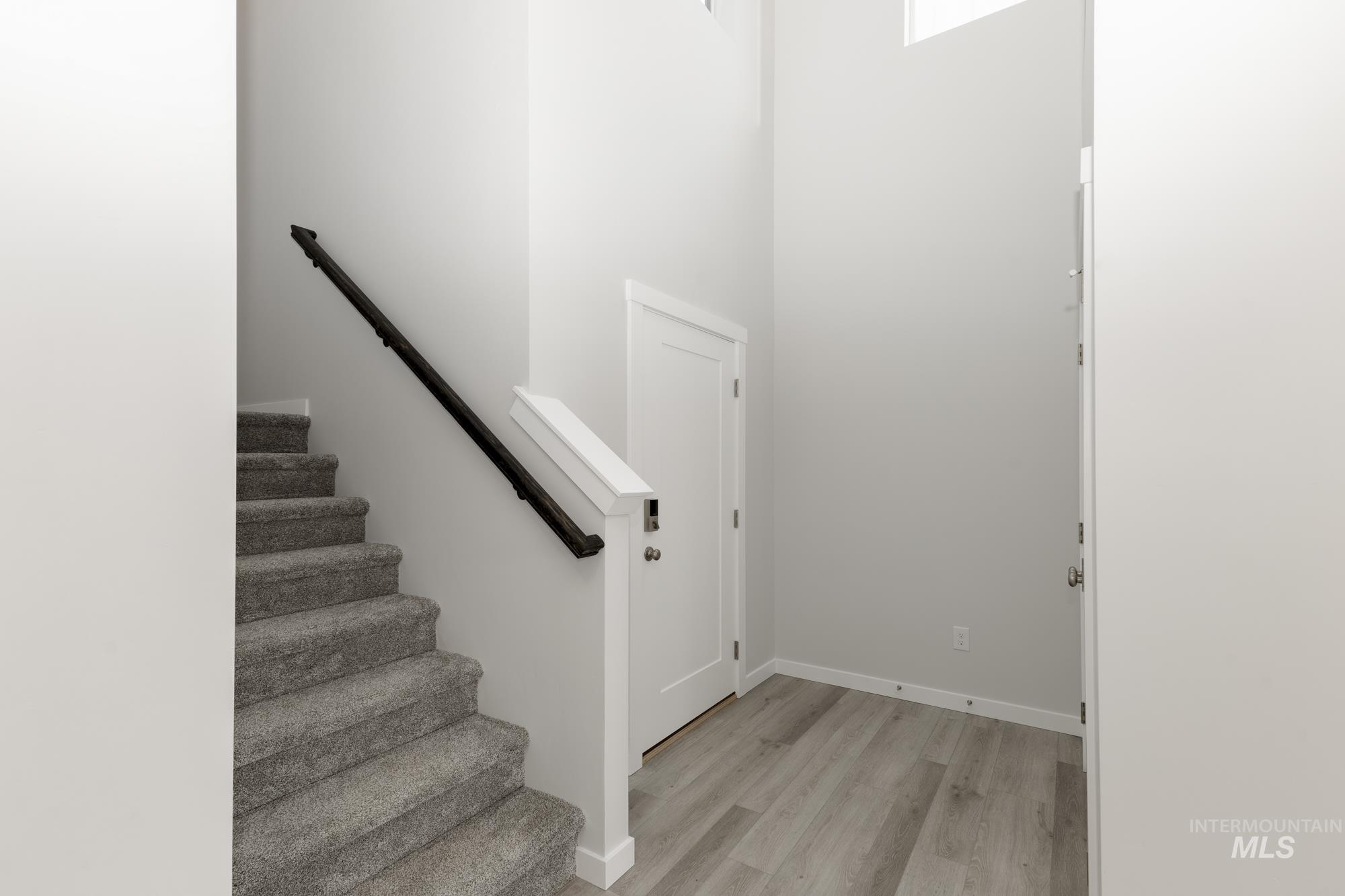 Stairway with wood finished floors and baseboards
