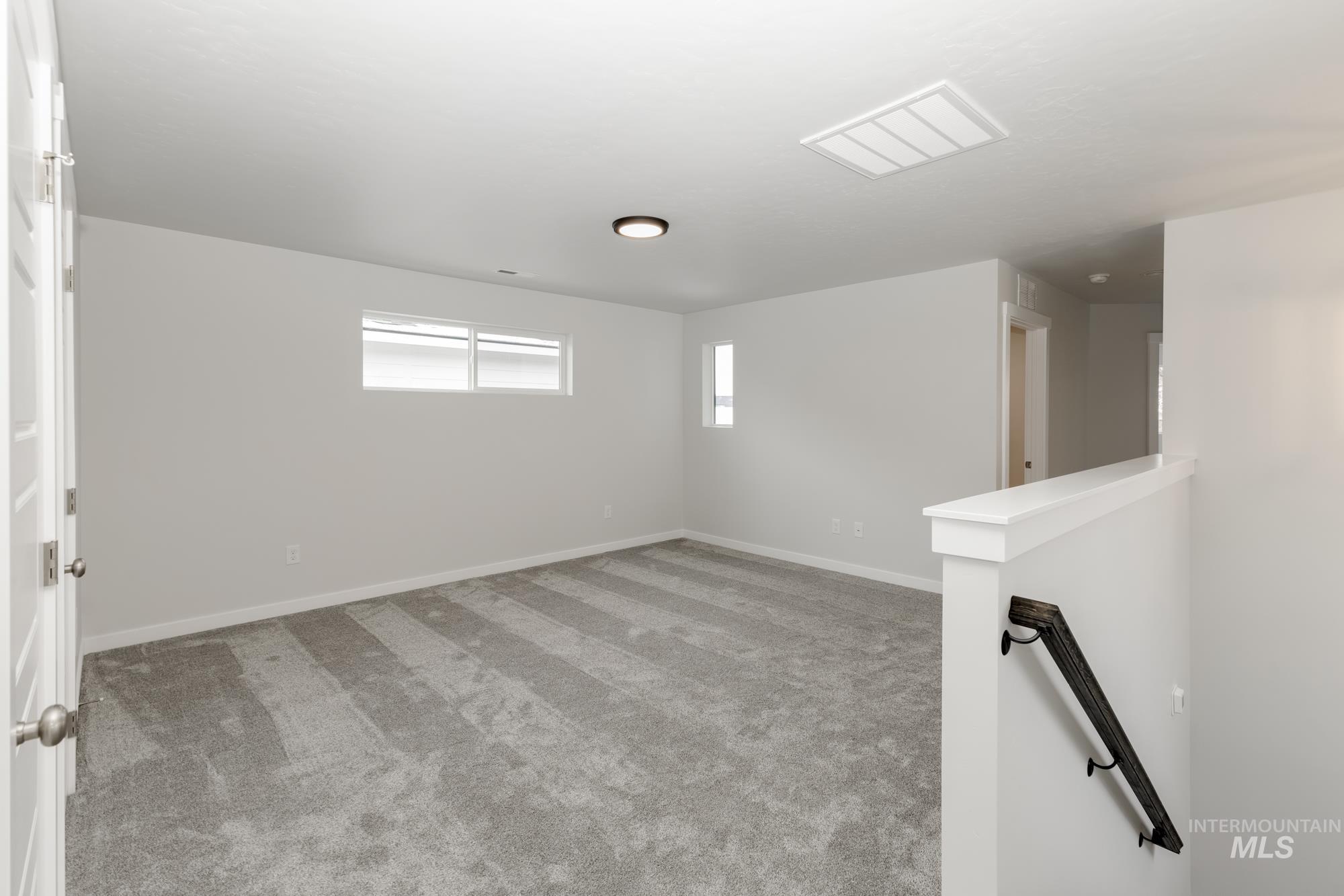 Spare room featuring light colored carpet and baseboards