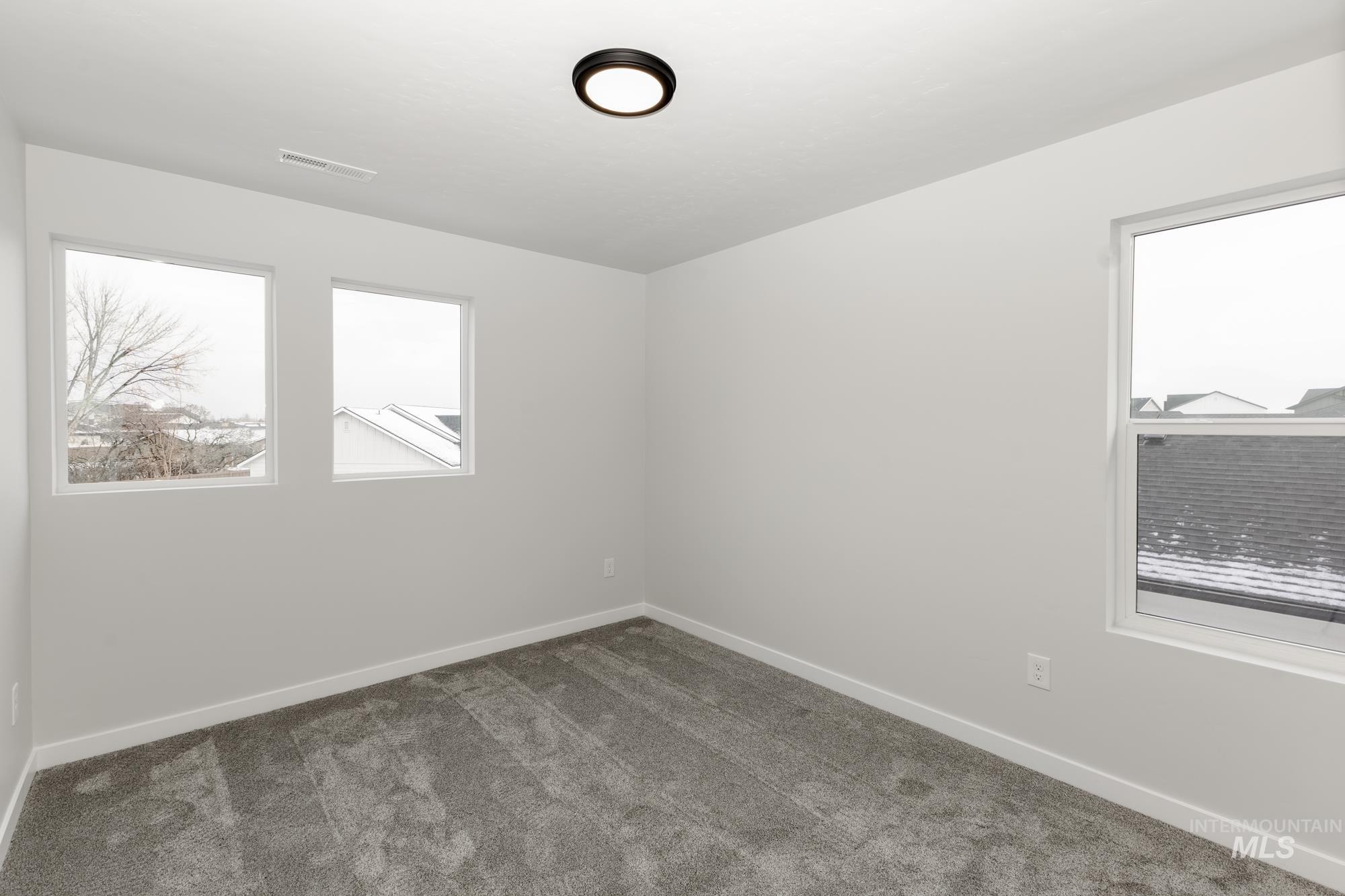 Carpeted spare room with baseboards