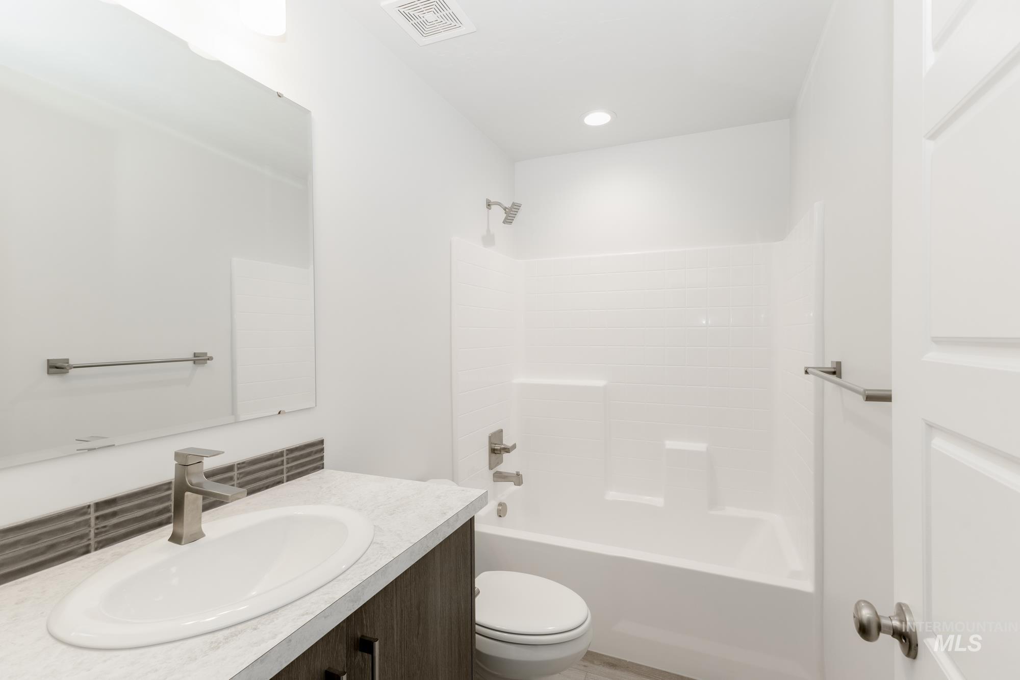 Full bath featuring vanity,  shower combination, and recessed lighting