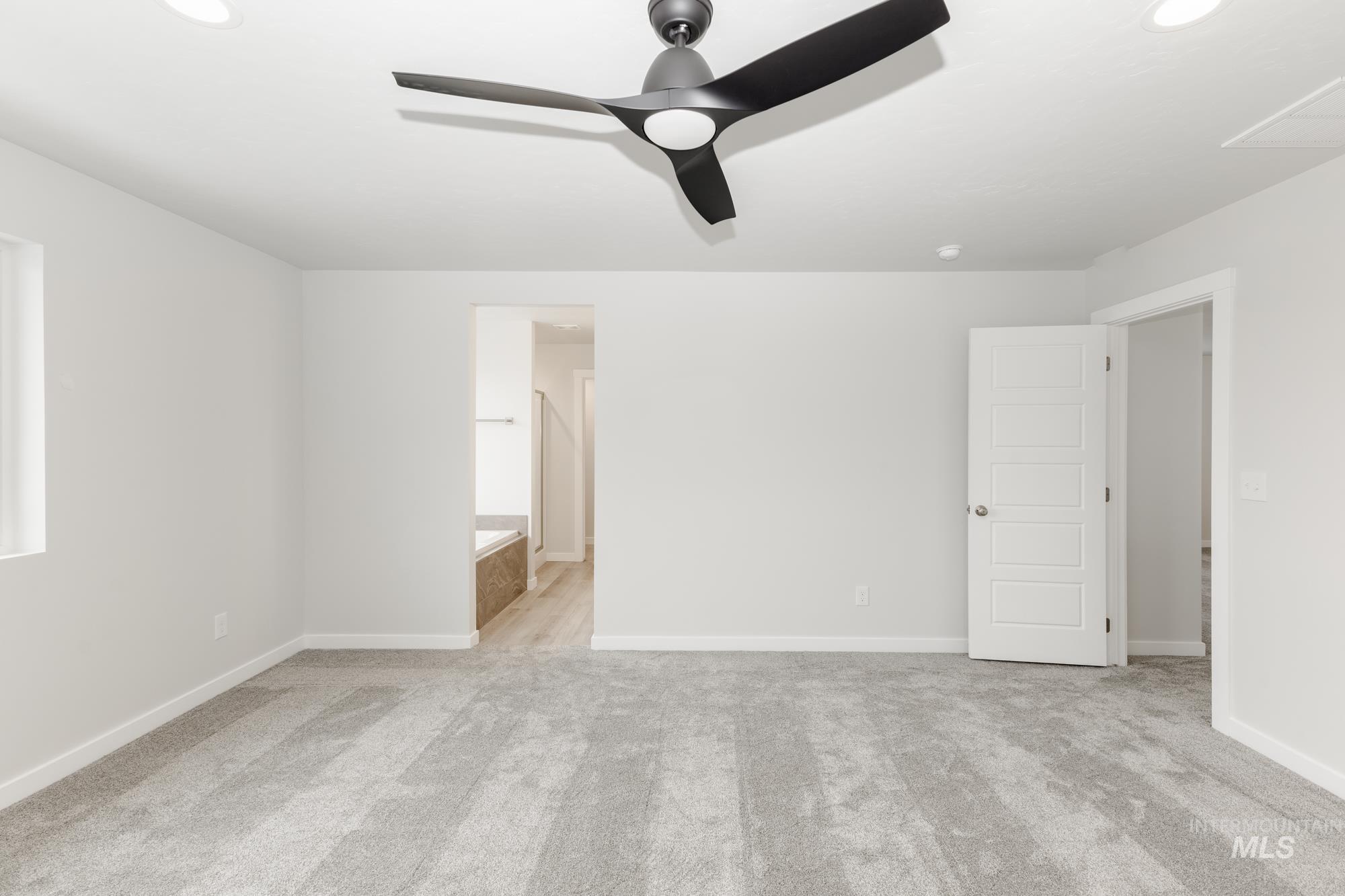 Unfurnished bedroom with light carpet, ceiling fan, recessed lighting, and connected bathroom