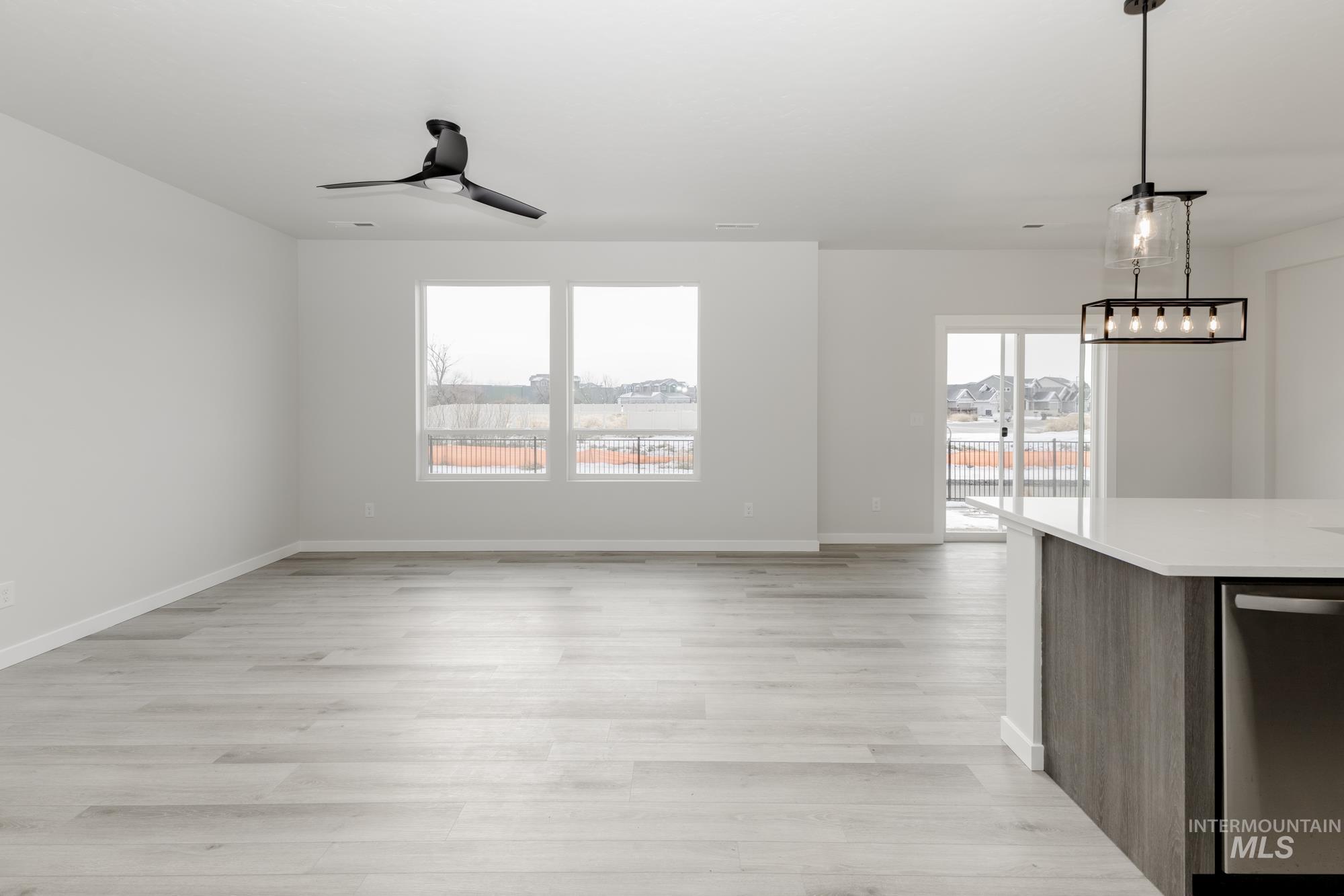 Unfurnished living room featuring light wood finished floors and a ceiling fan