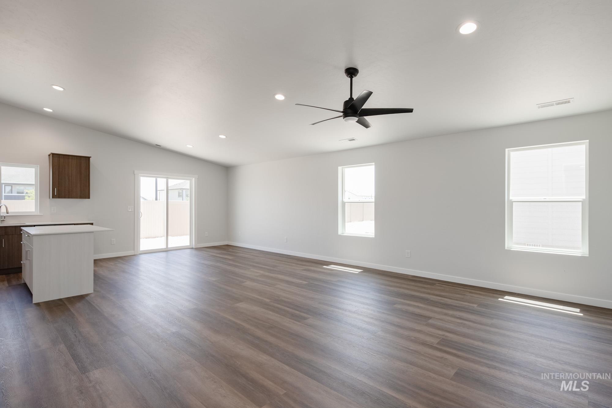 Unfurnished living room featuring recessed lighting, dark wood-type flooring, vaulted ceiling, and ceiling fan