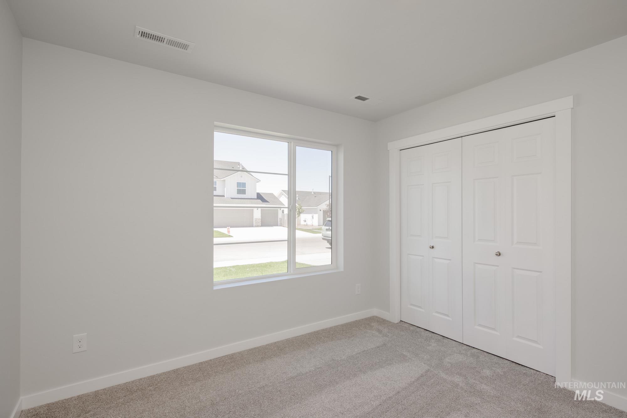 Unfurnished bedroom featuring light colored carpet and a closet