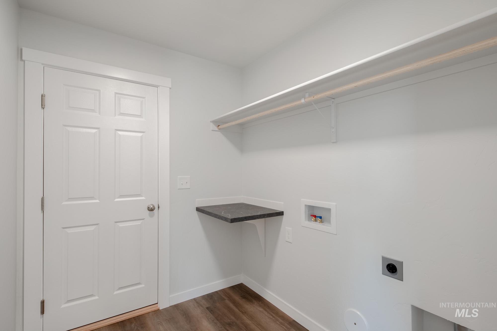 Washroom featuring washer hookup, dark wood finished floors, and hookup for an electric dryer