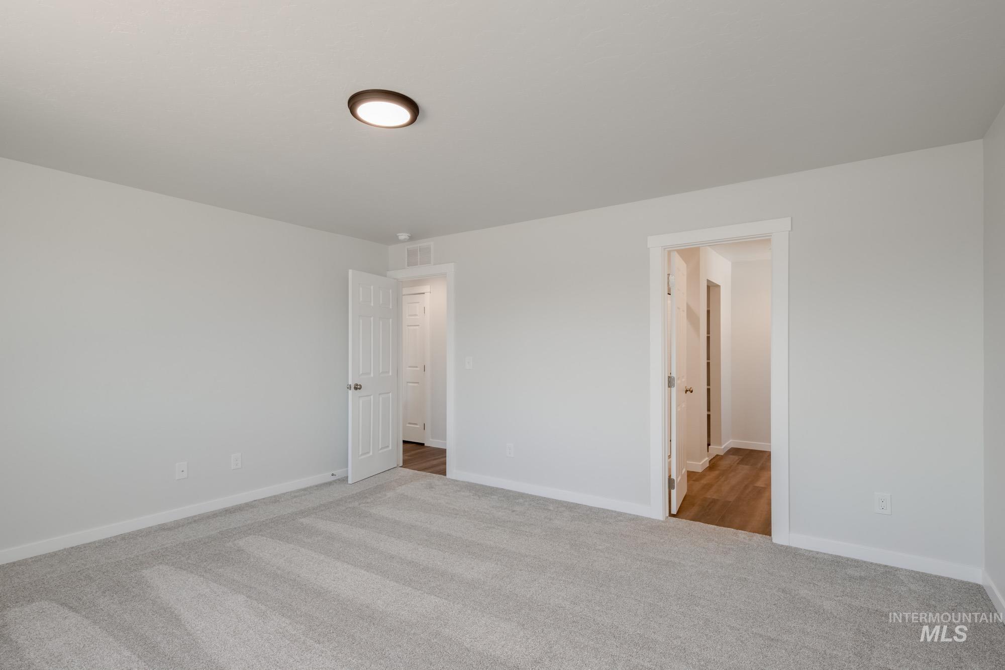 Unfurnished bedroom with carpet floors and baseboards