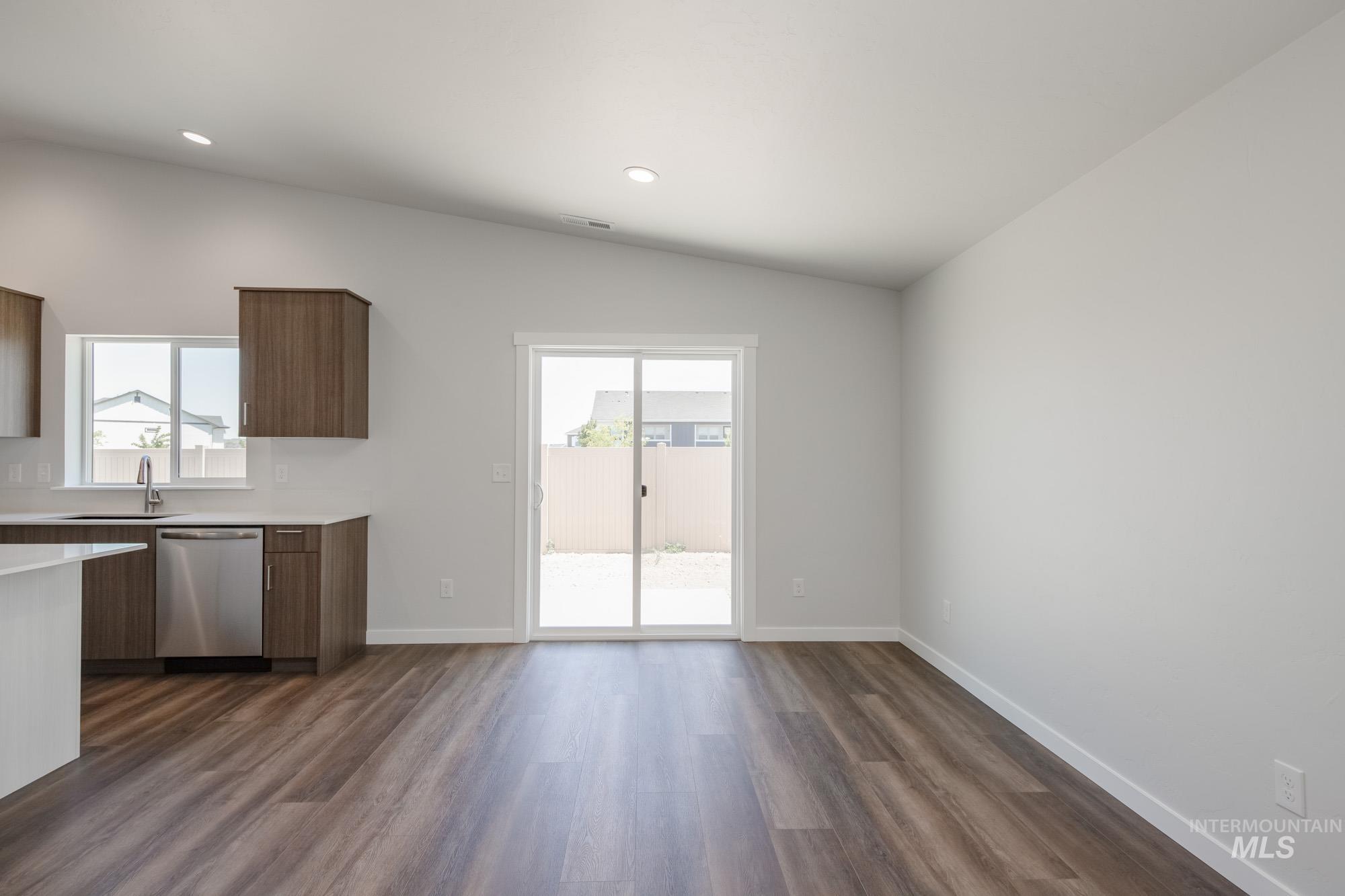 Kitchen with dishwasher, lofted ceiling, recessed lighting, dark wood-style floors, and modern cabinets