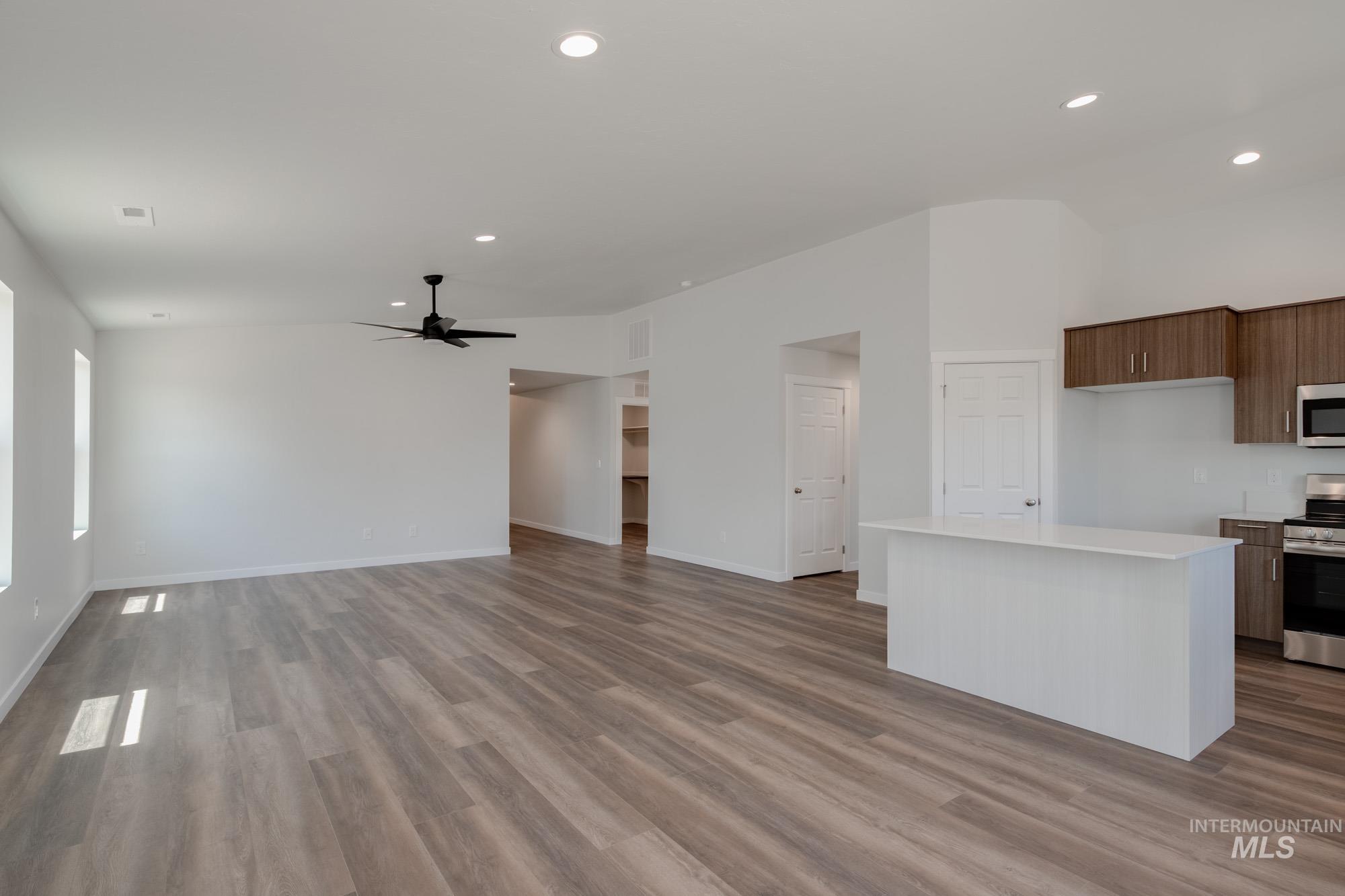 Kitchen with a center island, appliances with stainless steel finishes, recessed lighting, light wood-style floors, and open floor plan