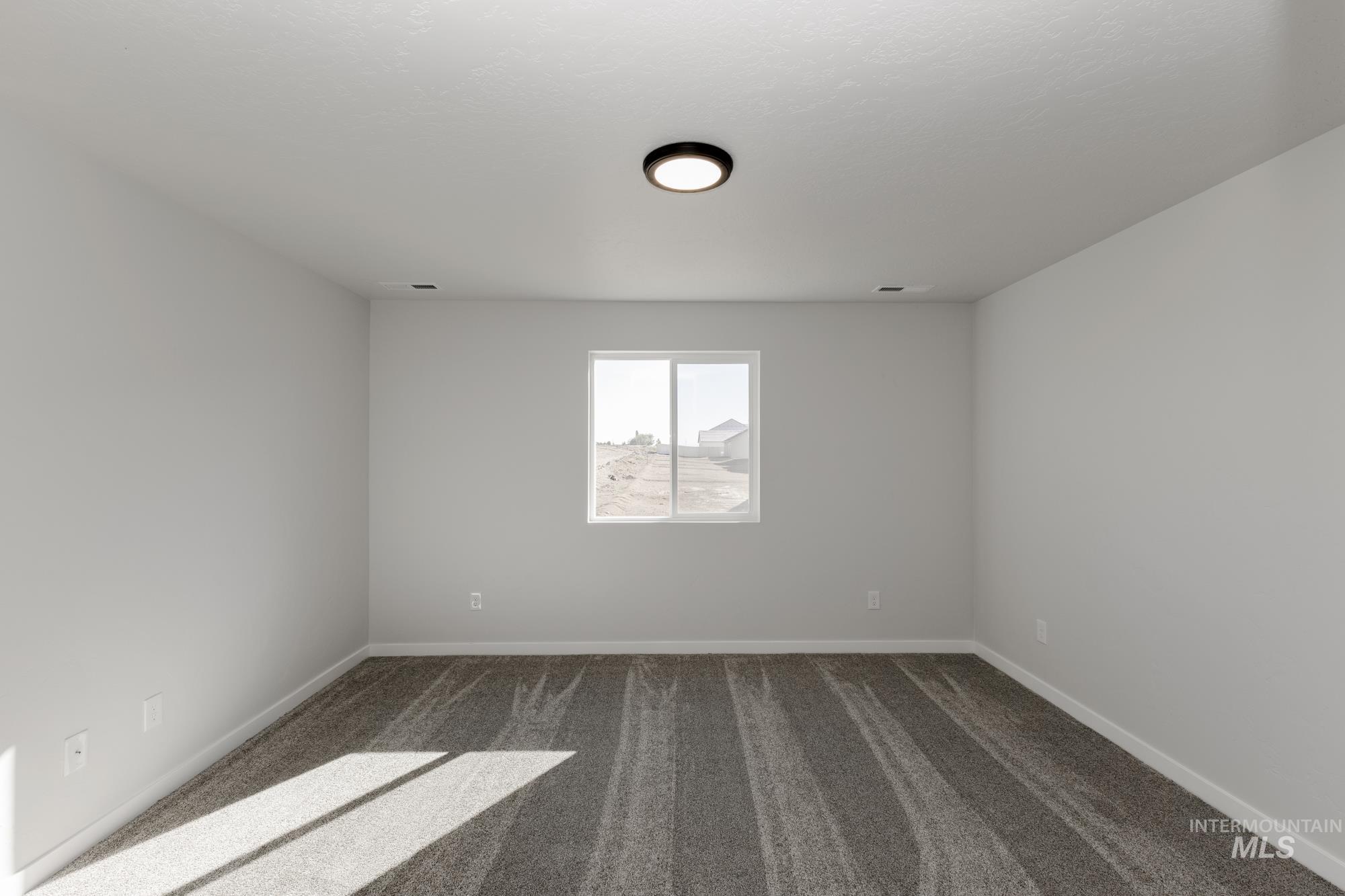 Carpeted spare room with baseboards