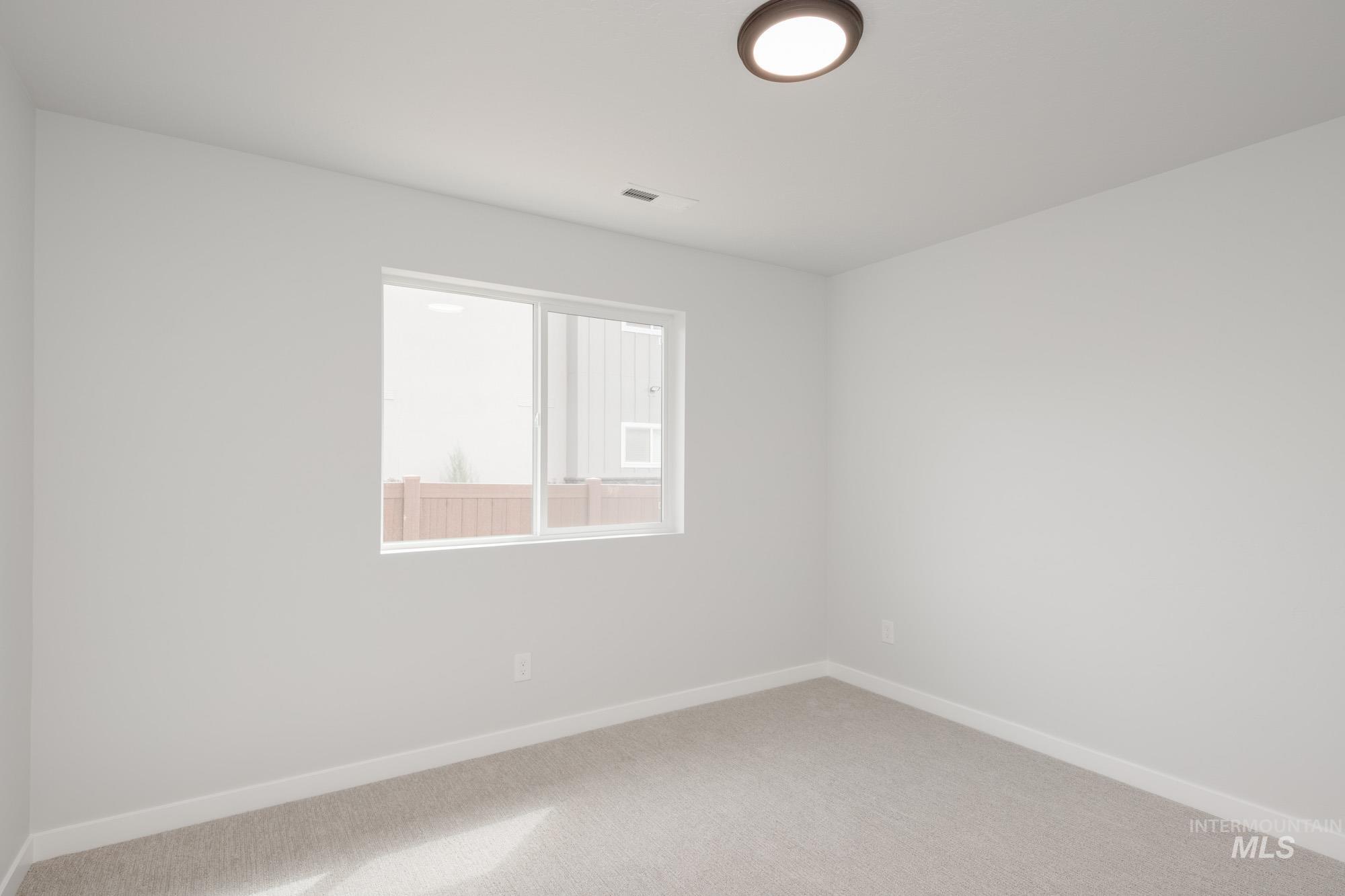 Empty room featuring baseboards and carpet