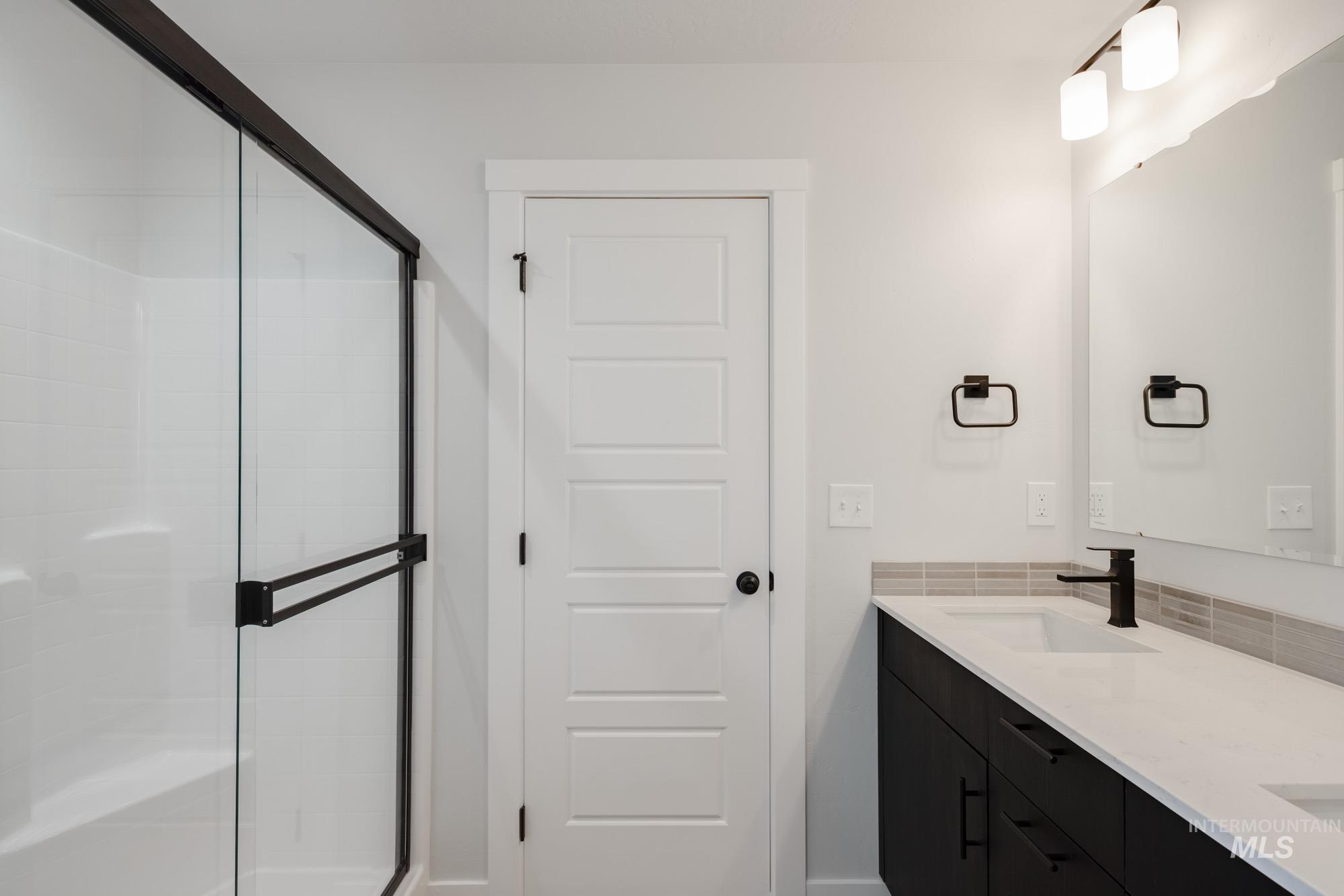 Full bath featuring a stall shower and double vanity